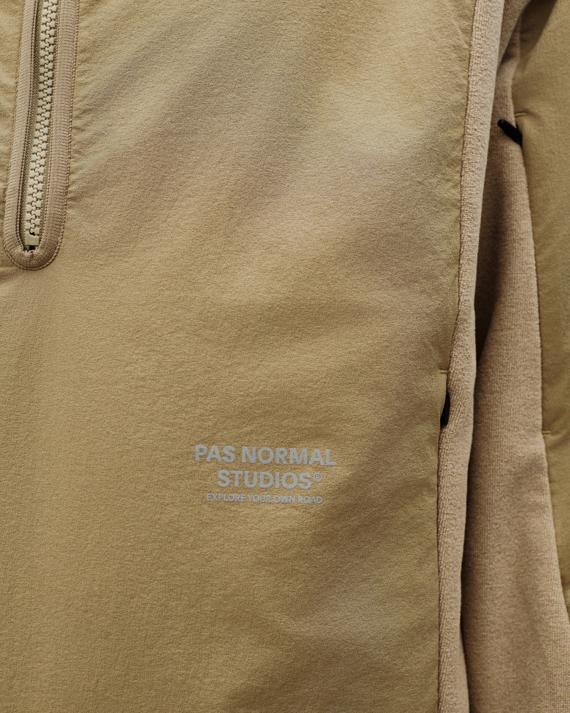 Beige Off-Race Light Fleece half-zip, detail view with quarter zip and embossed logo
