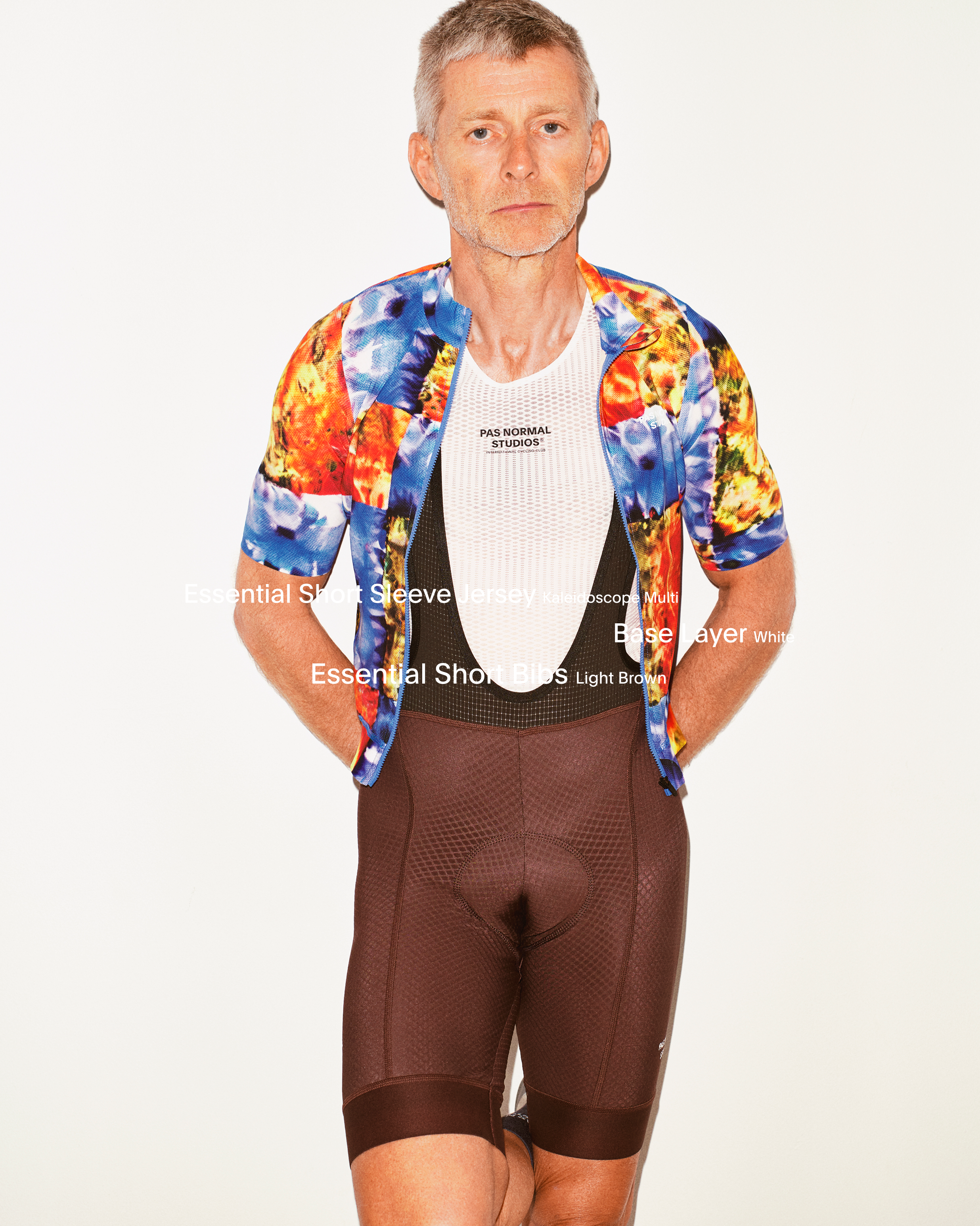Model wearing Essential Short Sleeve Jersey in multicolored print with Essential Bib Shorts in brown