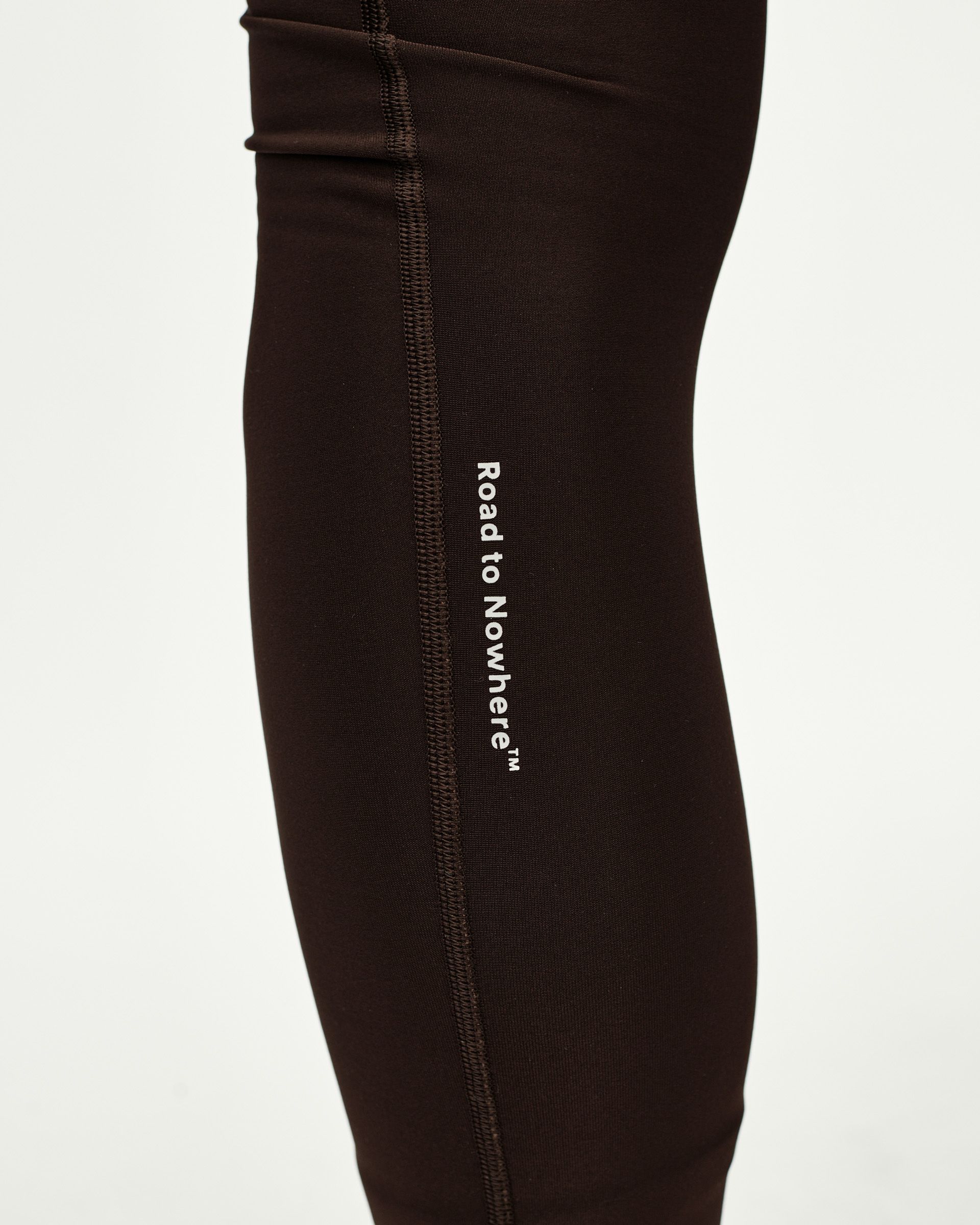 Dark Coffee brown Mechanism Thermal Long cycling bibs, side detail on model with white Road to Nowhere leg print