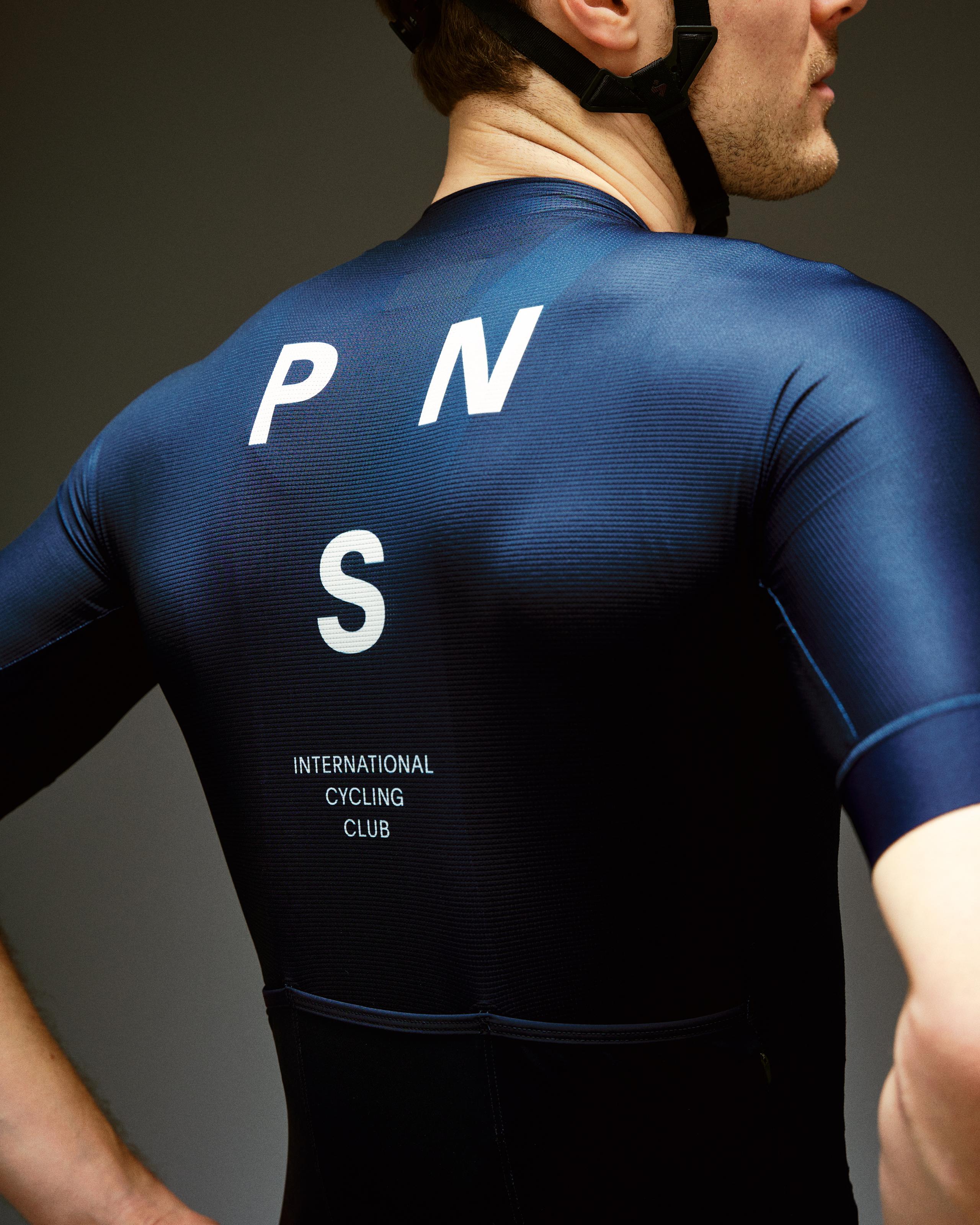 Navy Mechanism cycling jersey on model, rear view with white PNS logo and International Cycling Club text