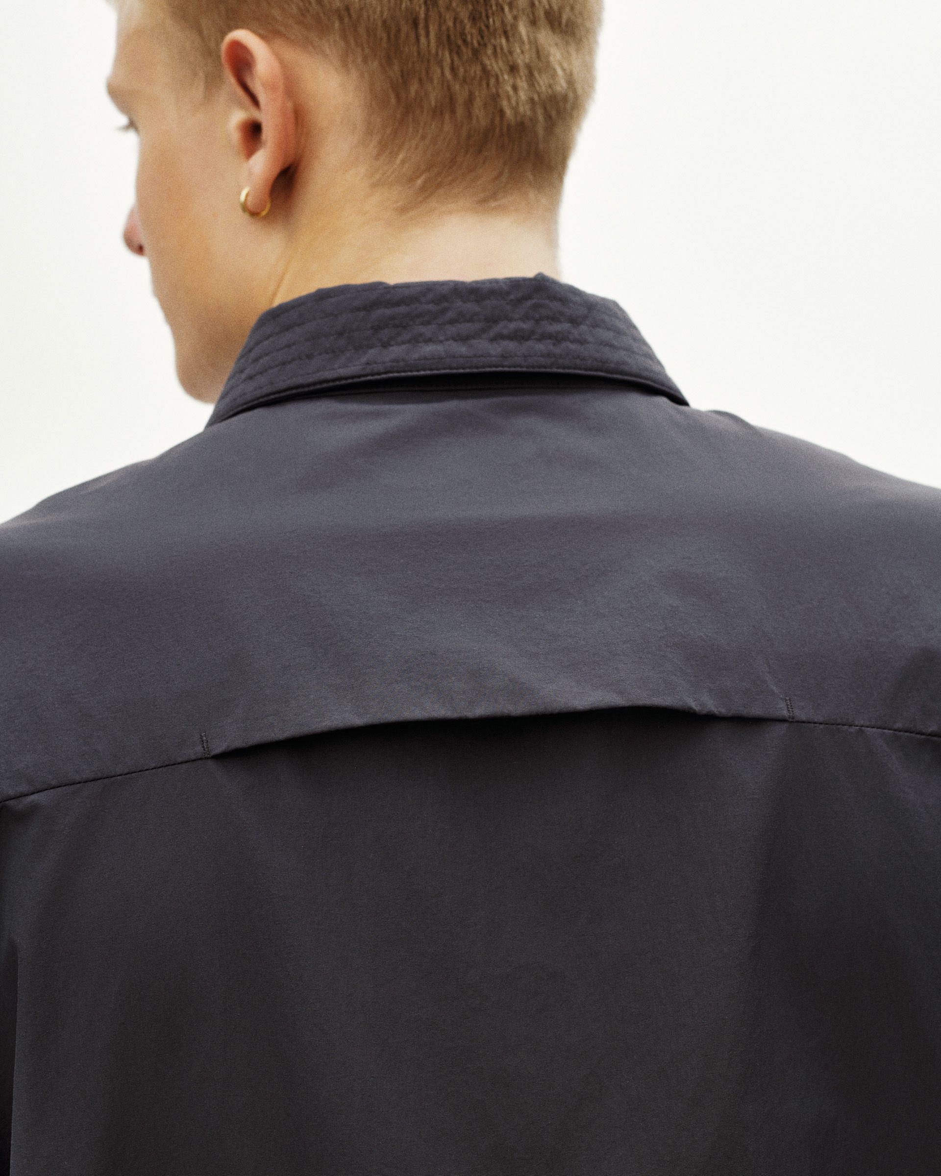 Grey Off-Race Utility jacket on model, rear view showing quilted collar detail
