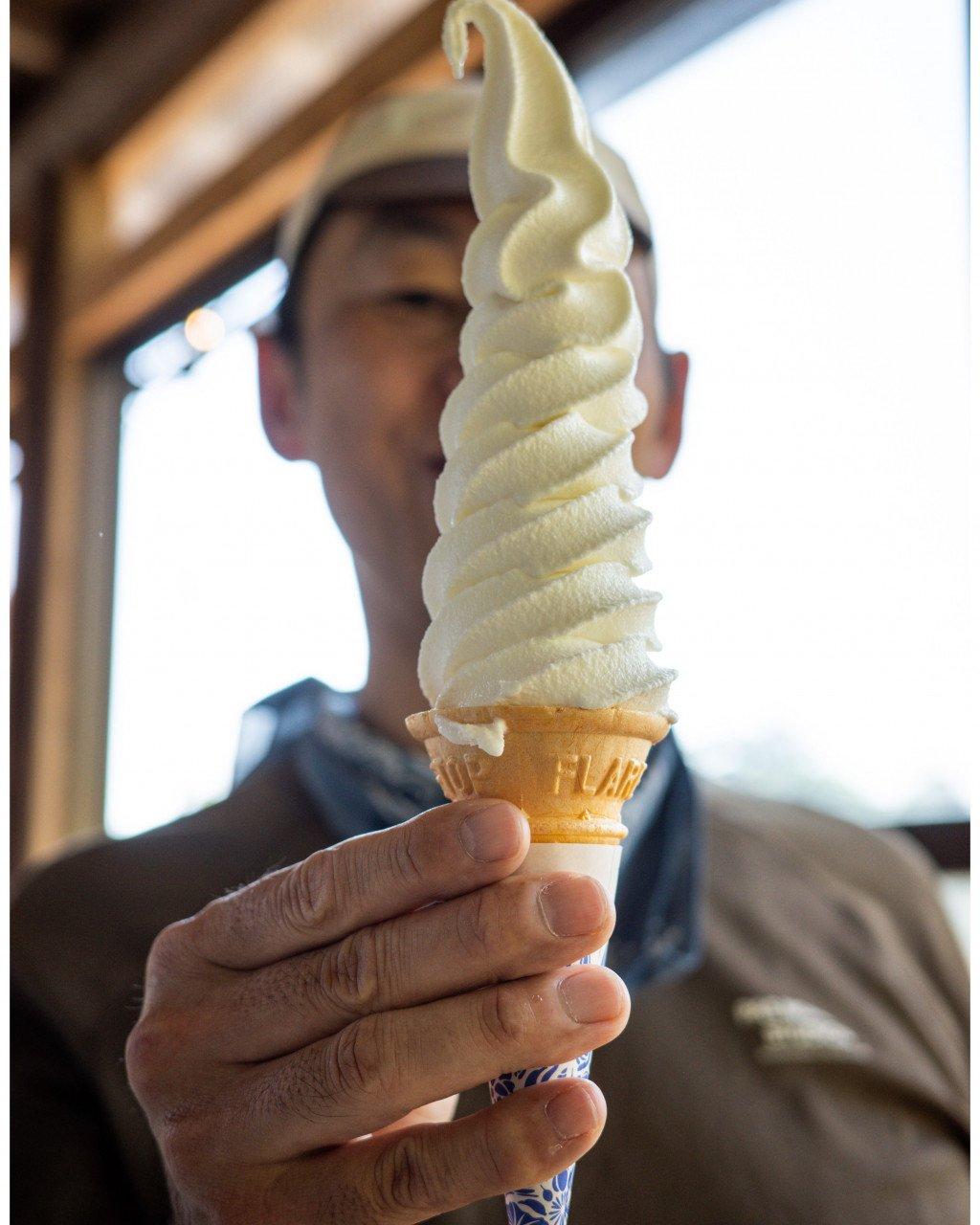 Model holding vanilla ice cream cone with blurred background showing casual cycling apparel