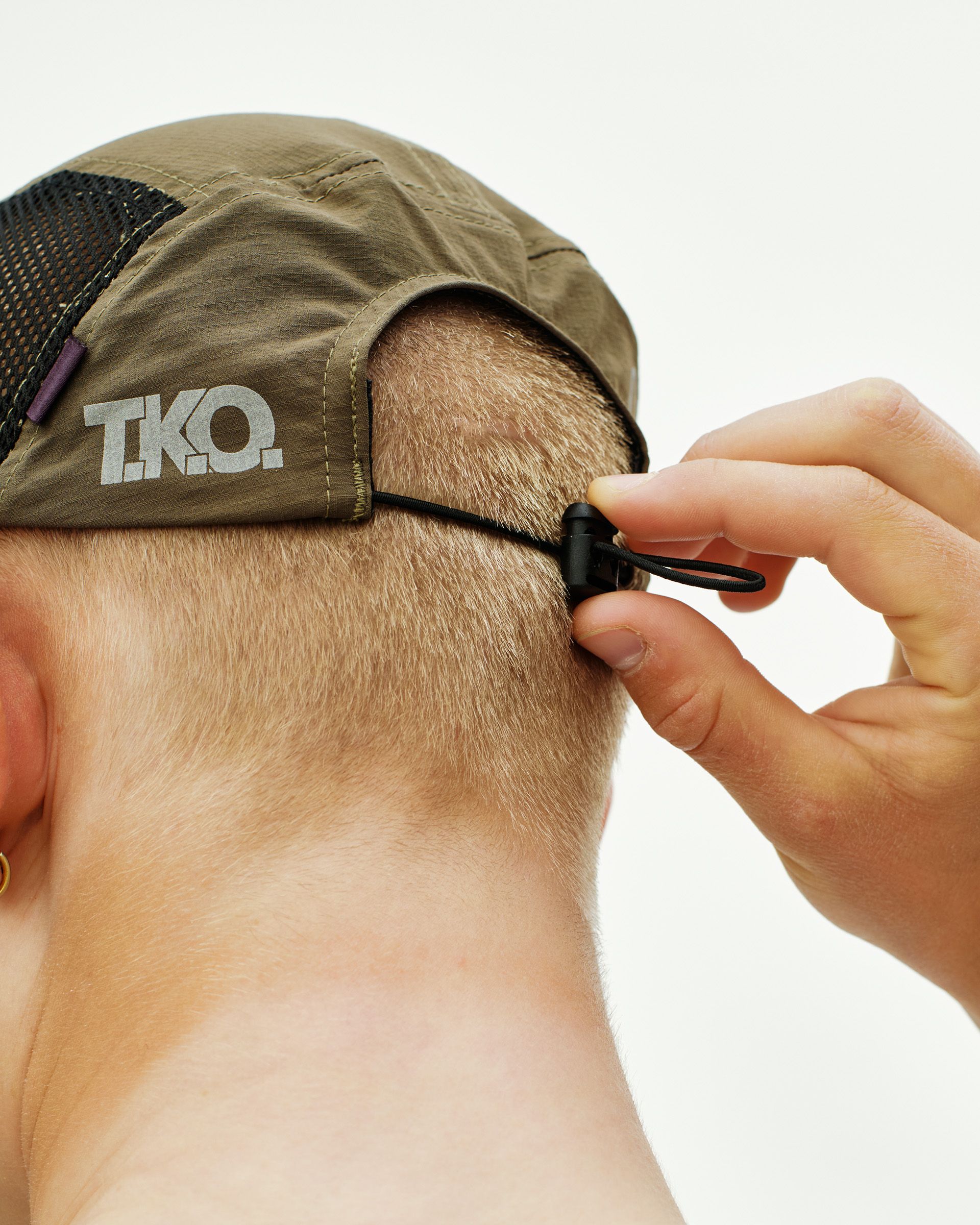 Dark Stone T.K.O. Balance cap on model, rear view with adjustable strap and white logo print