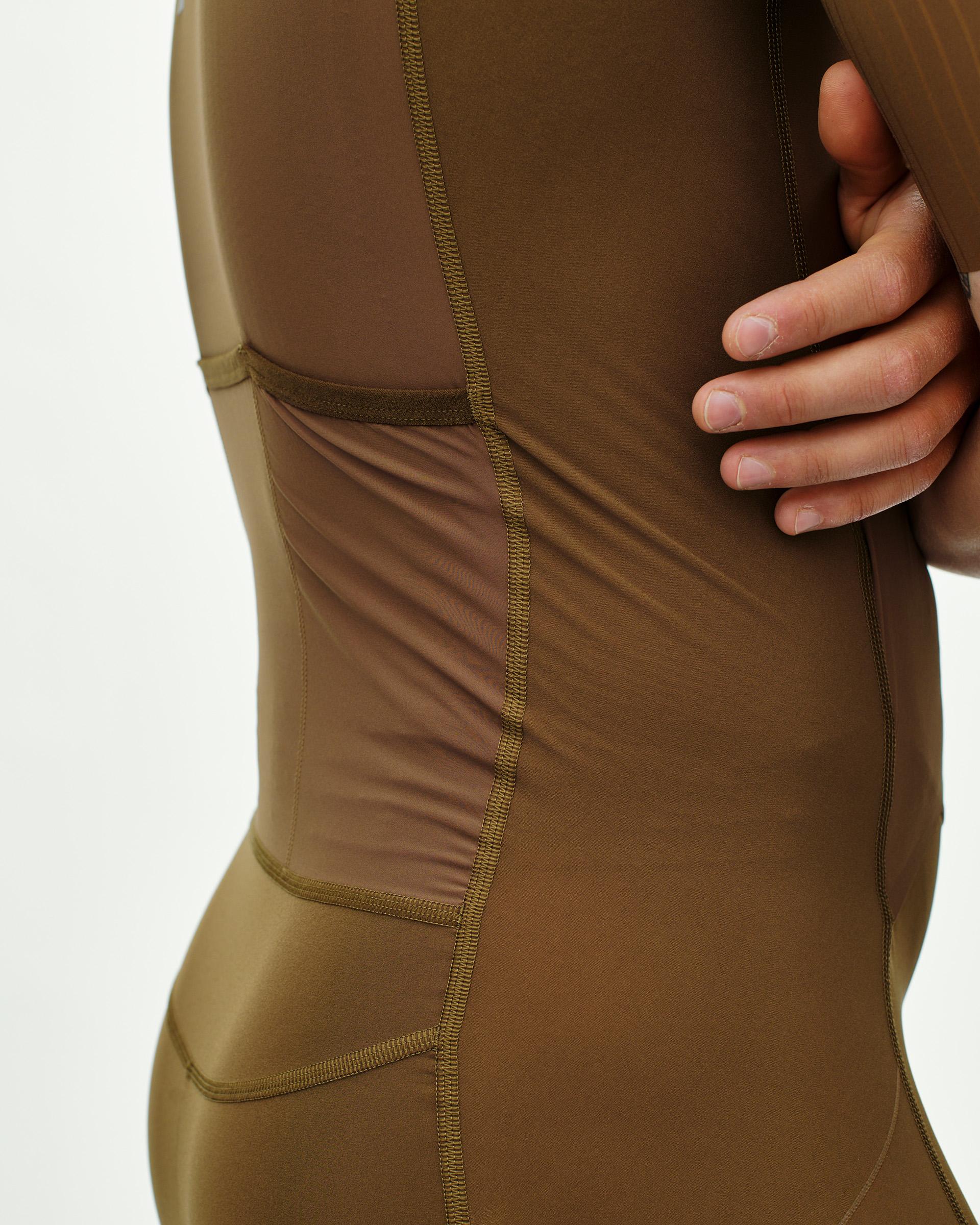Brown PAS Mechanism Pro speedsuit, side view on model with contrast stitching and mesh panels