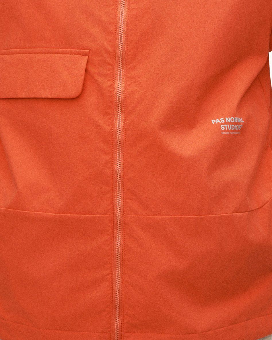 Orange jacket with reflective logo and full-length zipper for low-light visibility