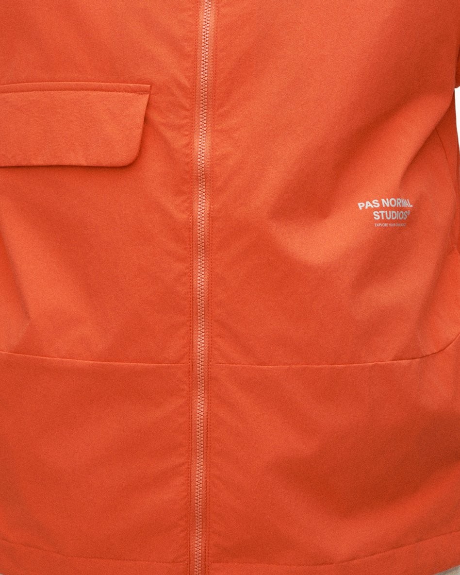 Orange jacket with reflective logo and full-length zipper for low-light visibility
