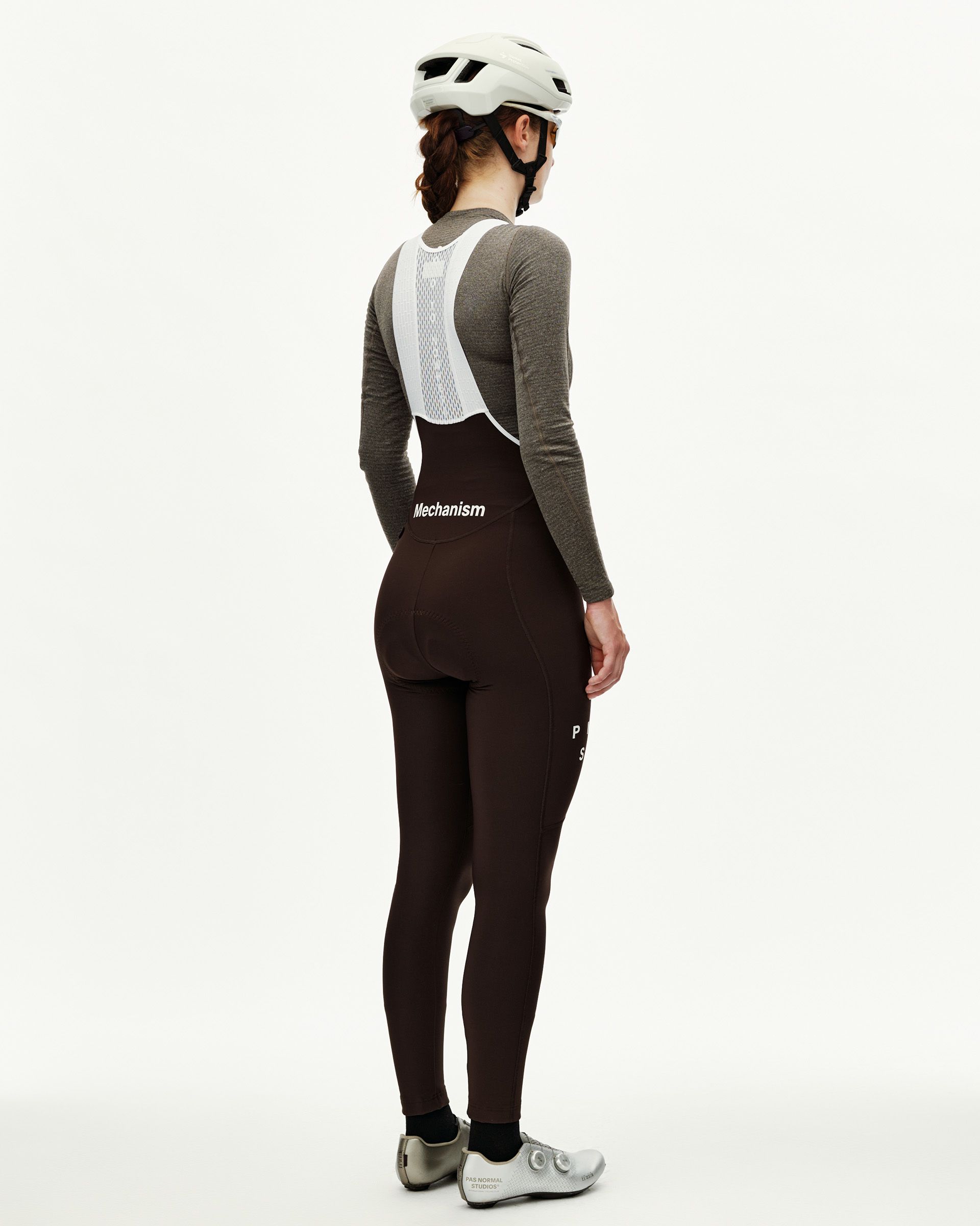 Dark Coffee brown Mechanism women's thermal cycling bib tights on model, rear view with white mesh bib straps