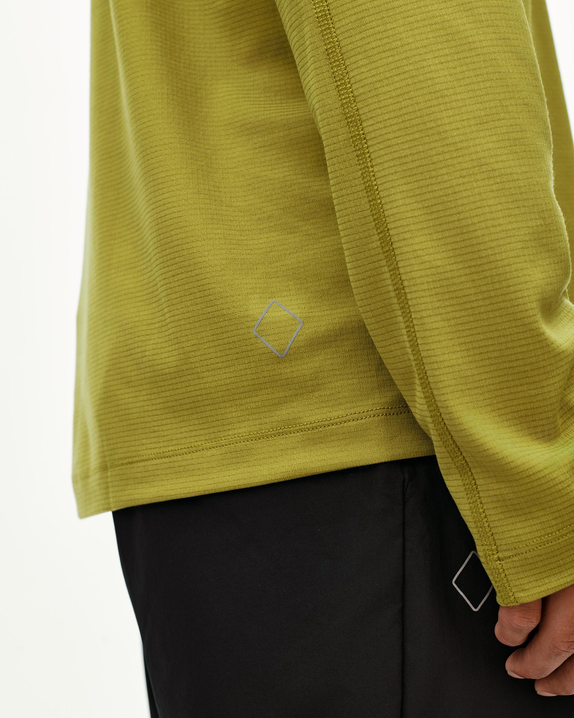 Dark Lime Balance long sleeve T-shirt, side detail on model showing ribbed texture and diamond logo