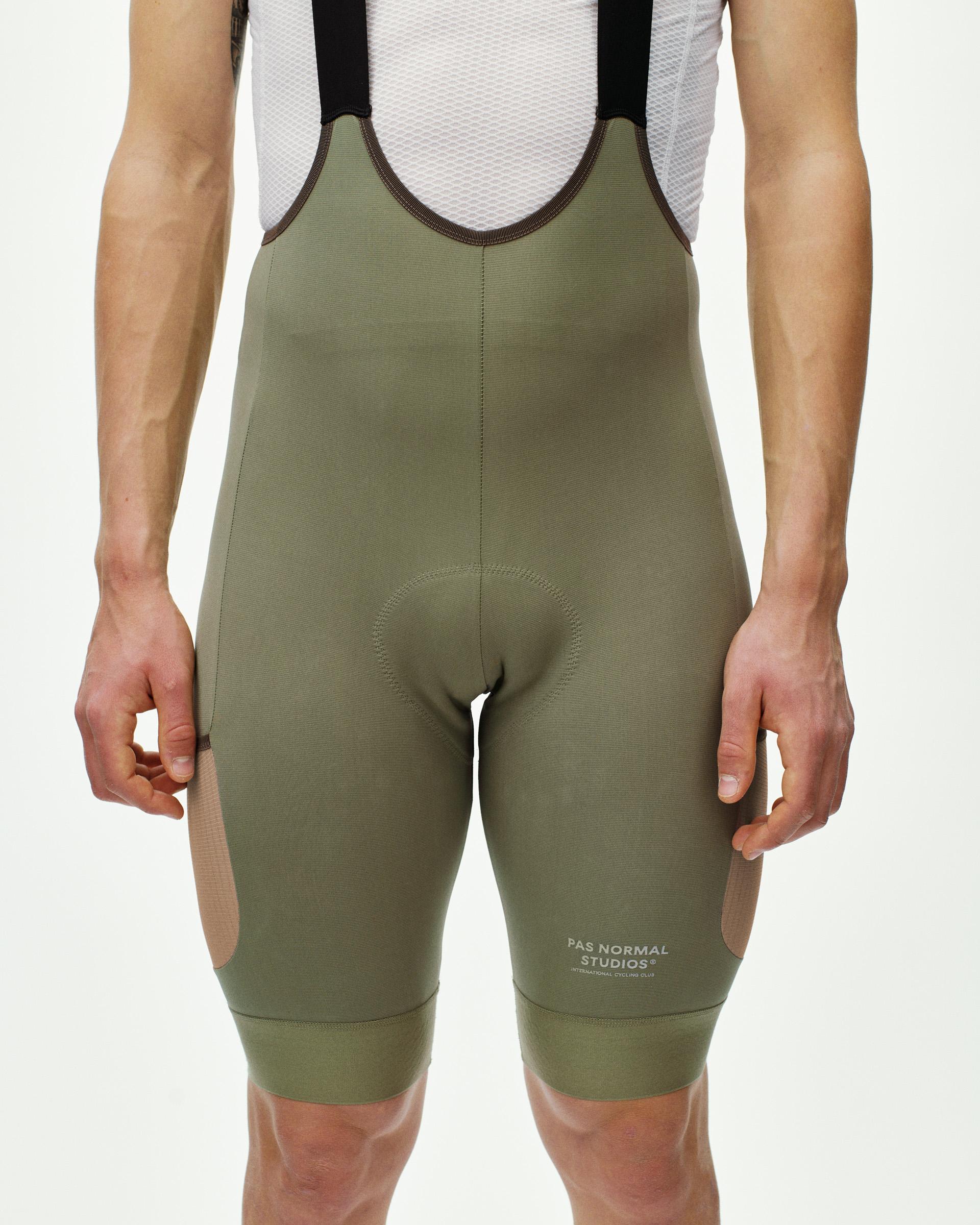 Light Olive Escapism Cargo cycling bibs on model, front view with black shoulder straps