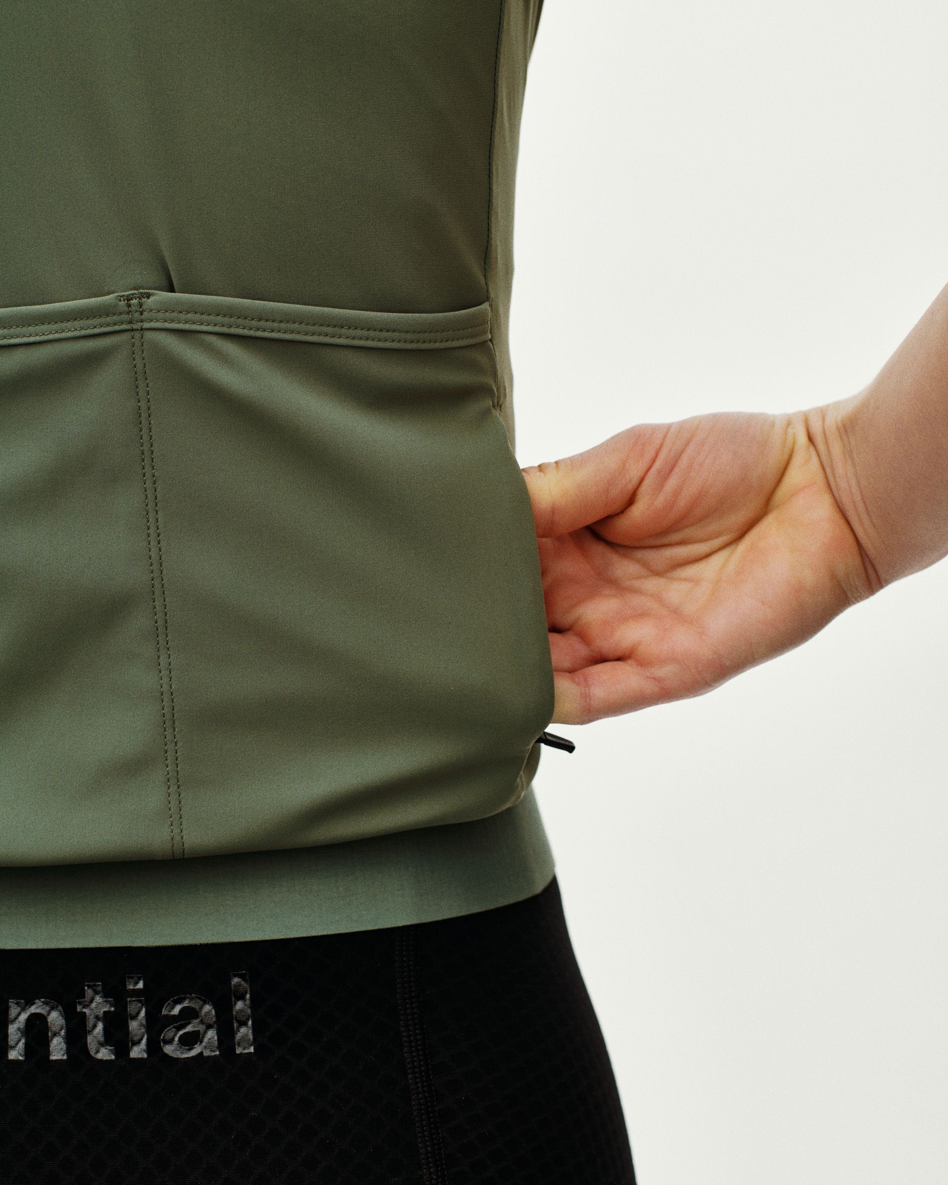 Green Essential cycling jersey on model showing side seam detail and elastic waistband