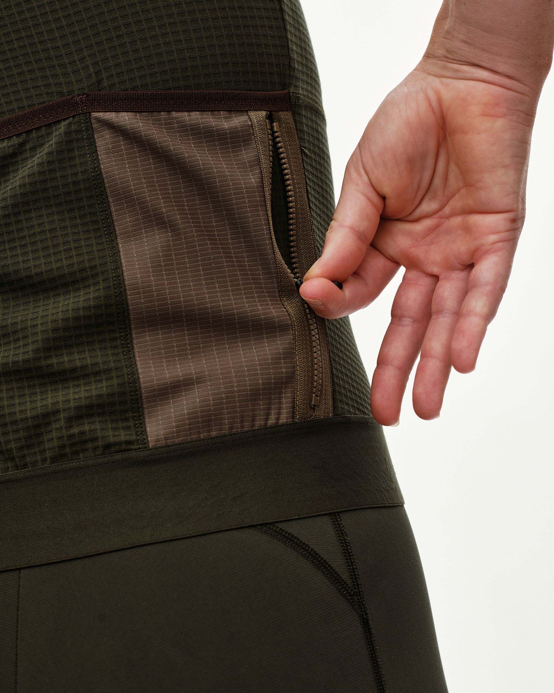 Dark Olive Escapism cycling jersey, side detail on model showing zipped pocket with contrast panel