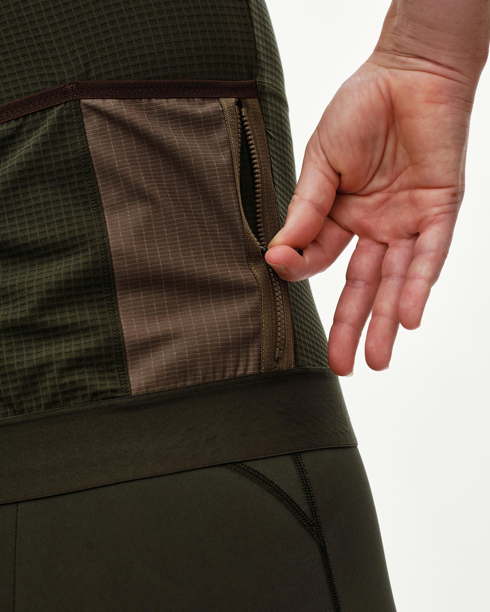 Dark Olive Escapism cycling jersey, side detail on model showing zipped pocket with contrast panel