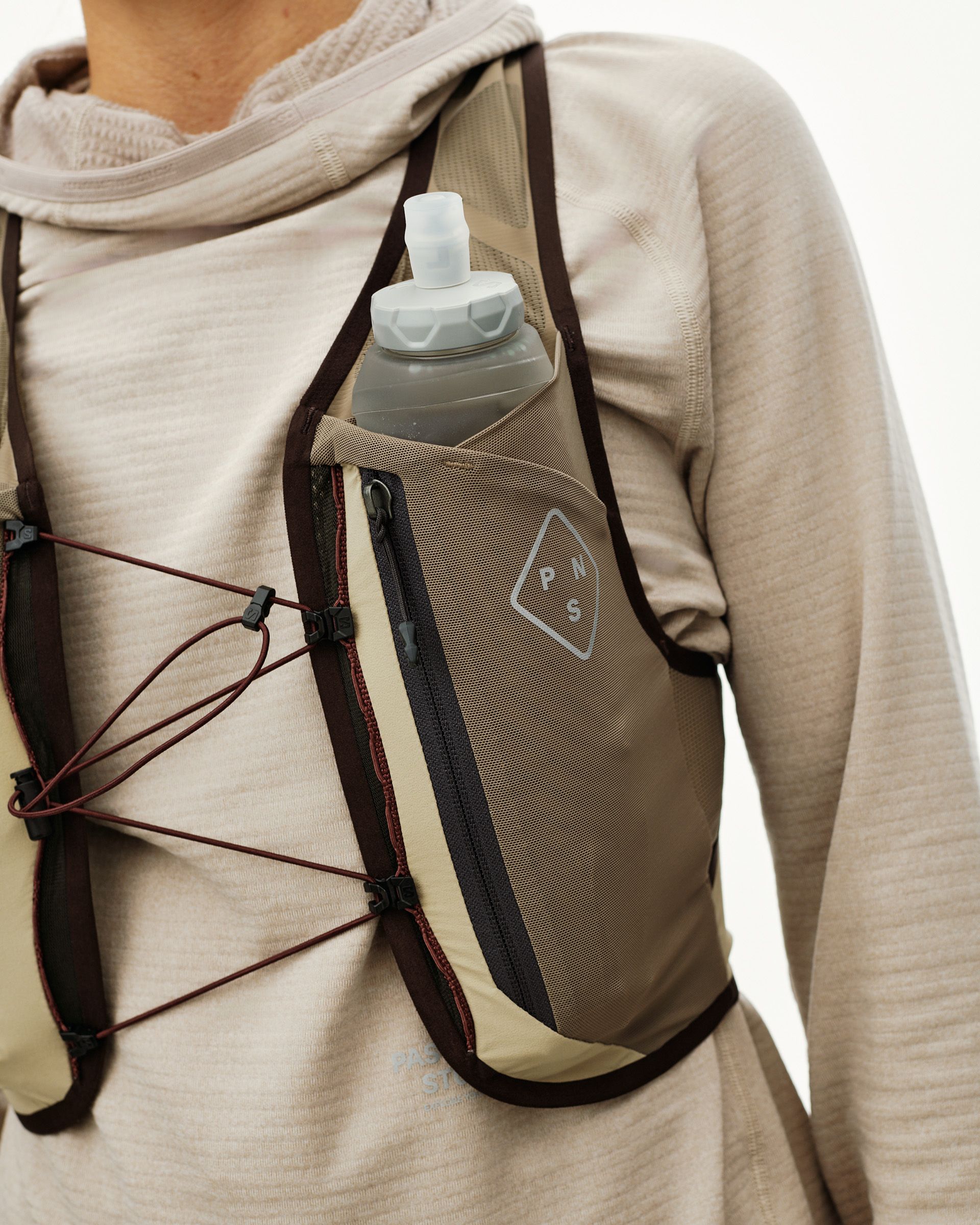 Light Brown Salomon Gravel Concept Skin 2 running vest on model, front detail with soft flask in chest pocket