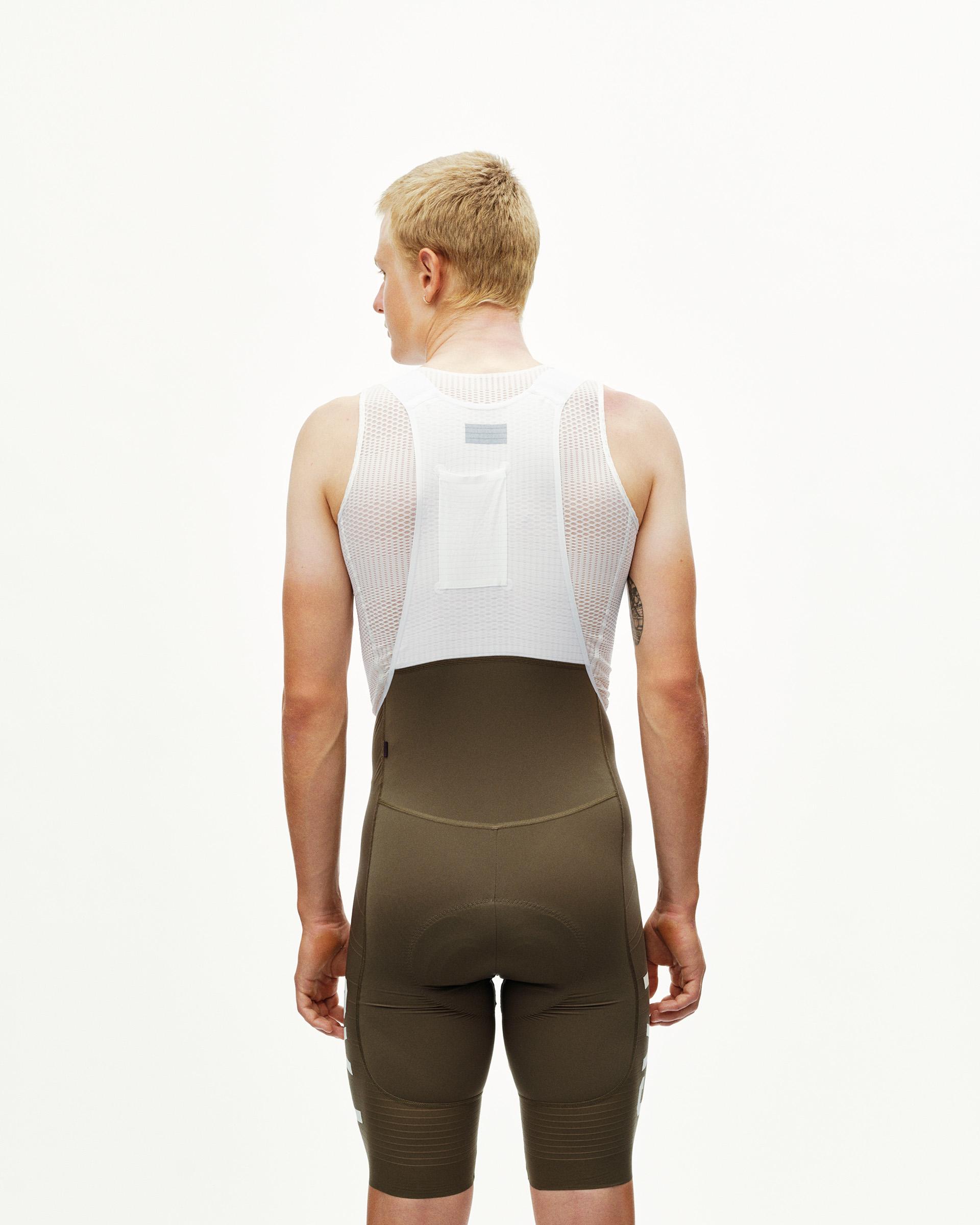 Dark Earth khaki PAS Mechanism Pro cycling bibs on model, rear view with white mesh bib straps