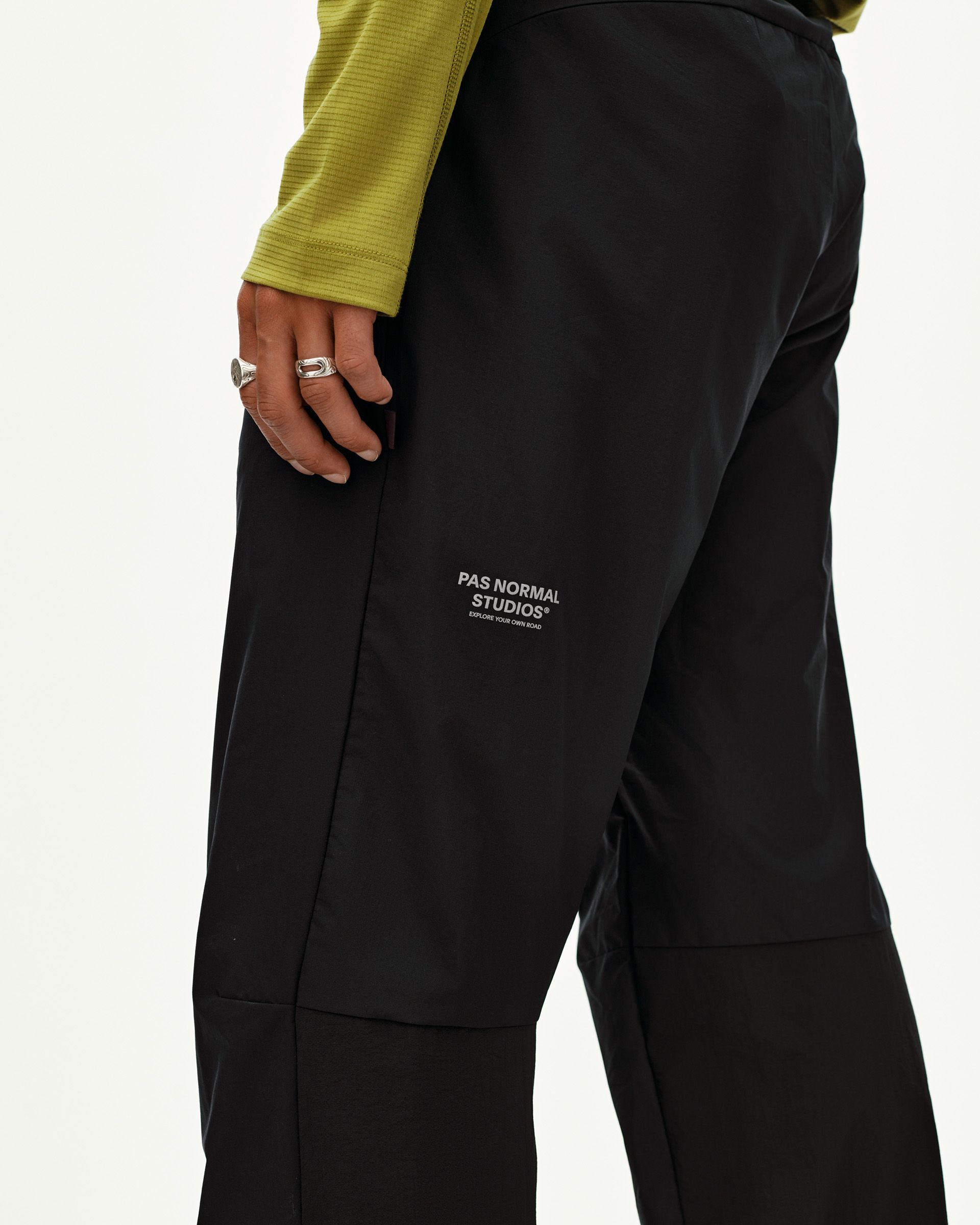 Black Balance Performance pants, side detail on model with contrast panel and small chest logo print