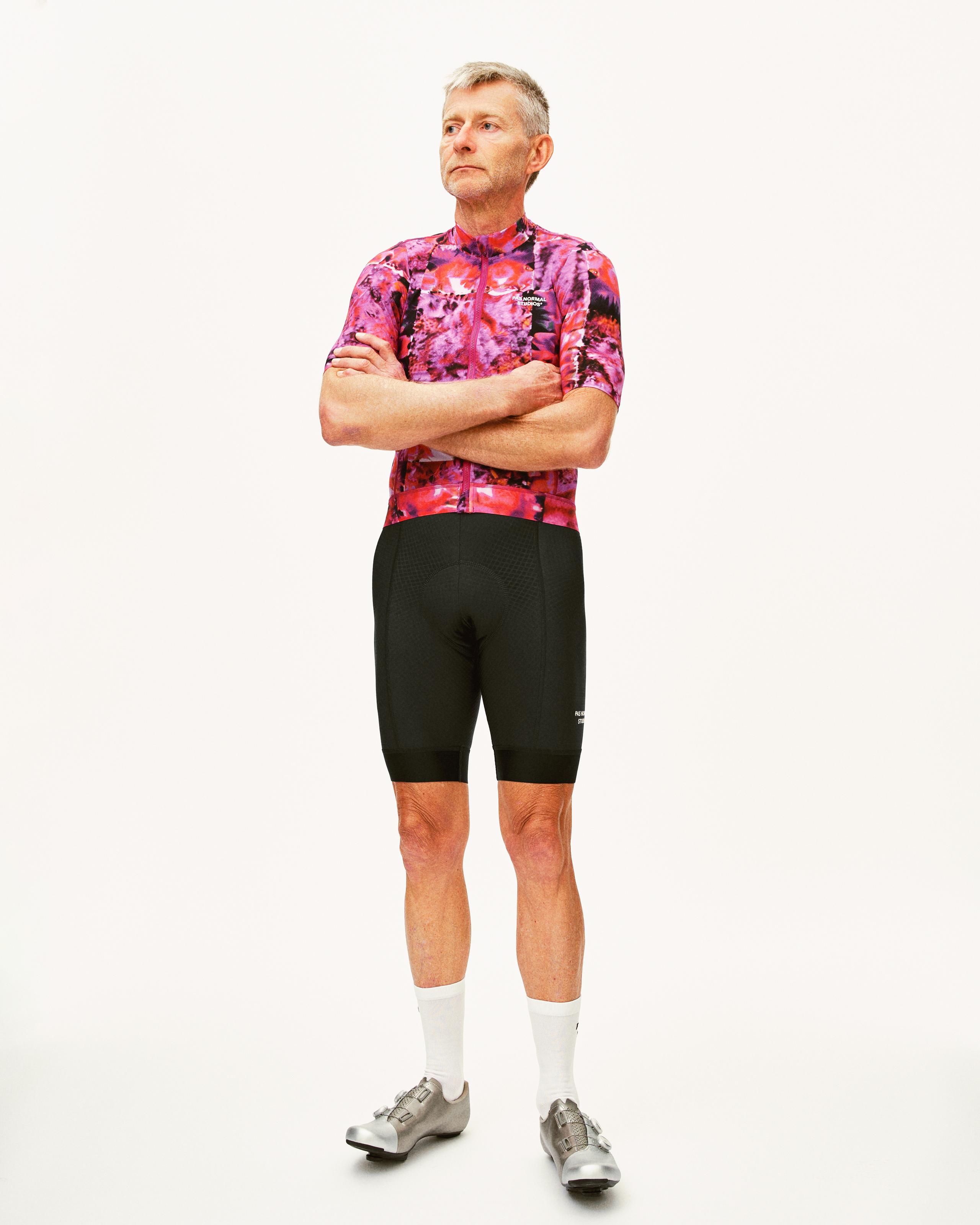 Black Essential cycling bibs on model, front view worn with pink floral jersey