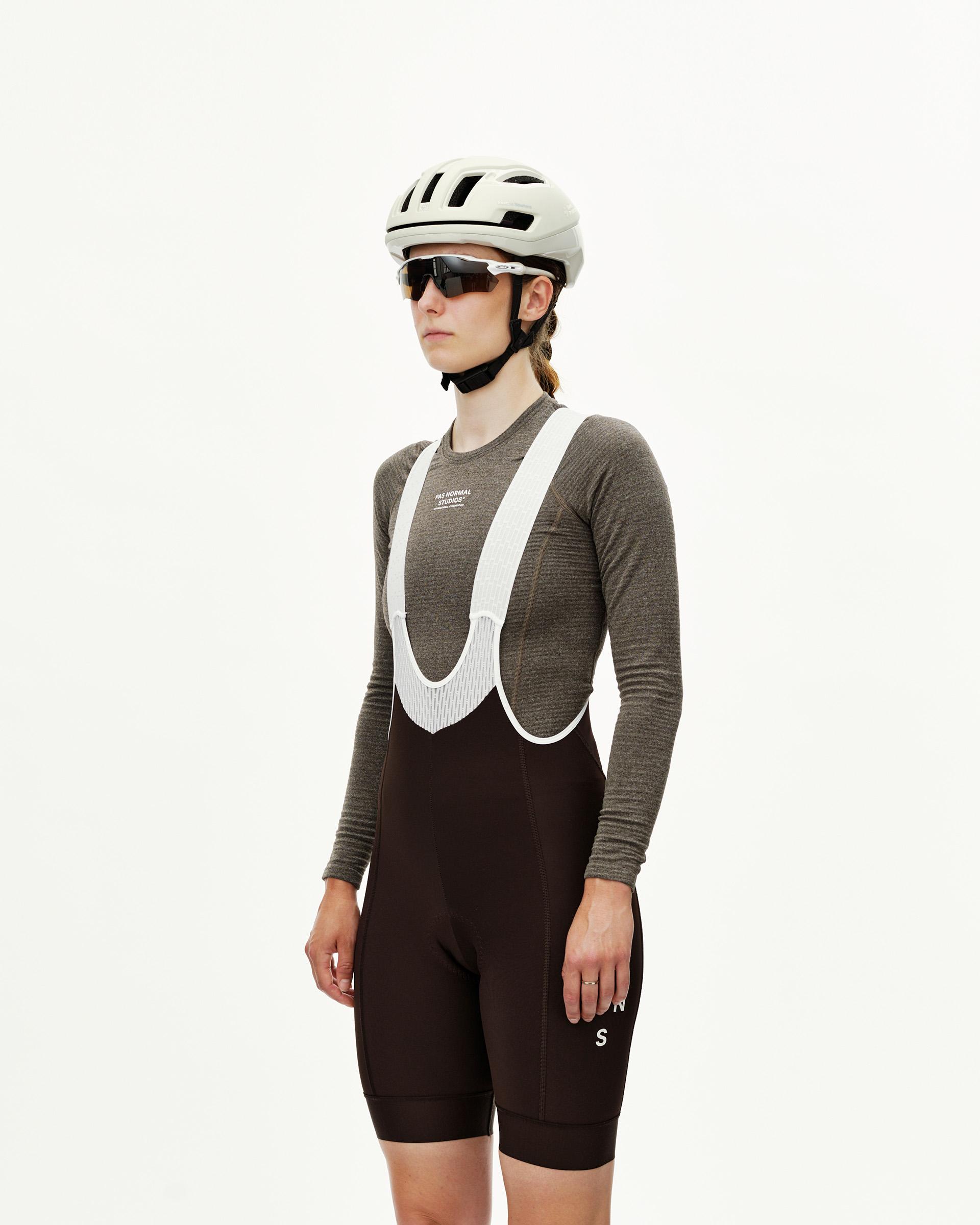 Dark Coffee brown Mechanism Thermal women's cycling bibs on model, front view with white ribbed bib straps