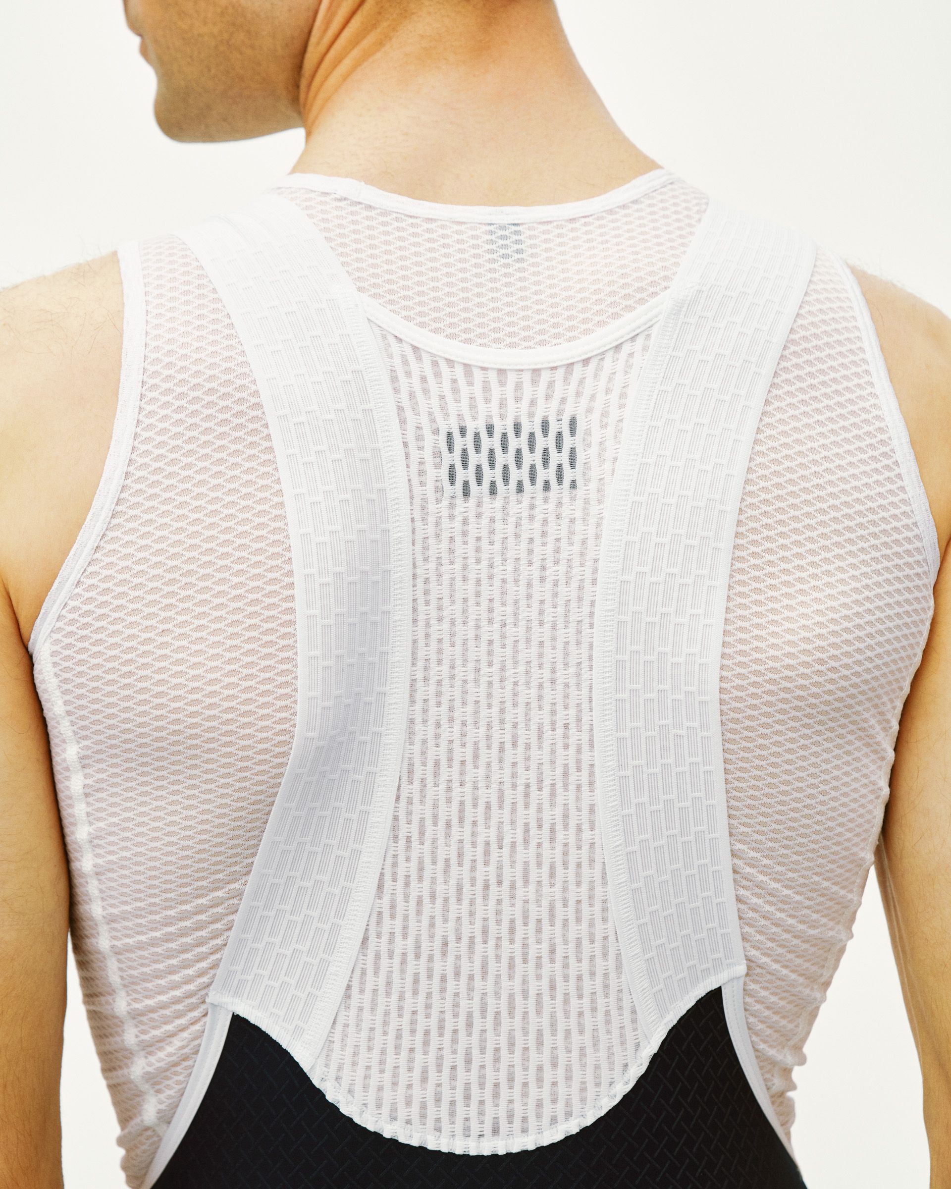 White Mechanism cycling bibs on model, rear view showing mesh back panel with central ventilation strip