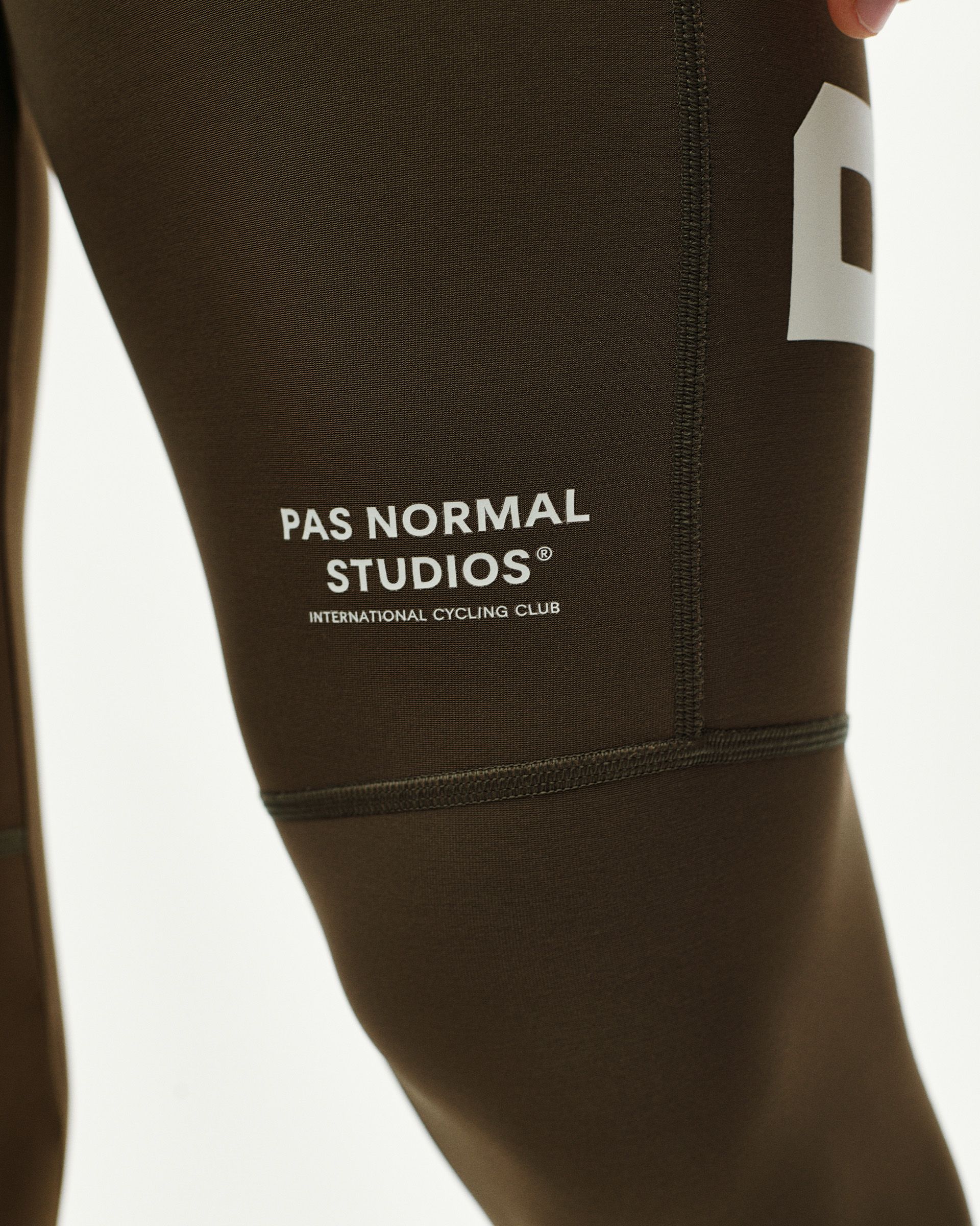 Dark Earth brown PAS Mechanism Thermal Long cycling bibs, thigh detail on model with white logo print