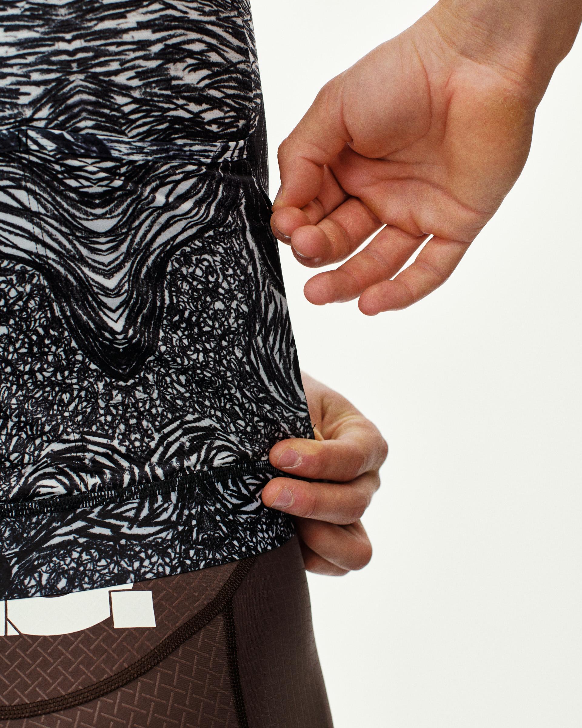 Iron Grey T.K.O. Mechanism cycling jersey, side detail on model showing hem and black-on-white abstract print