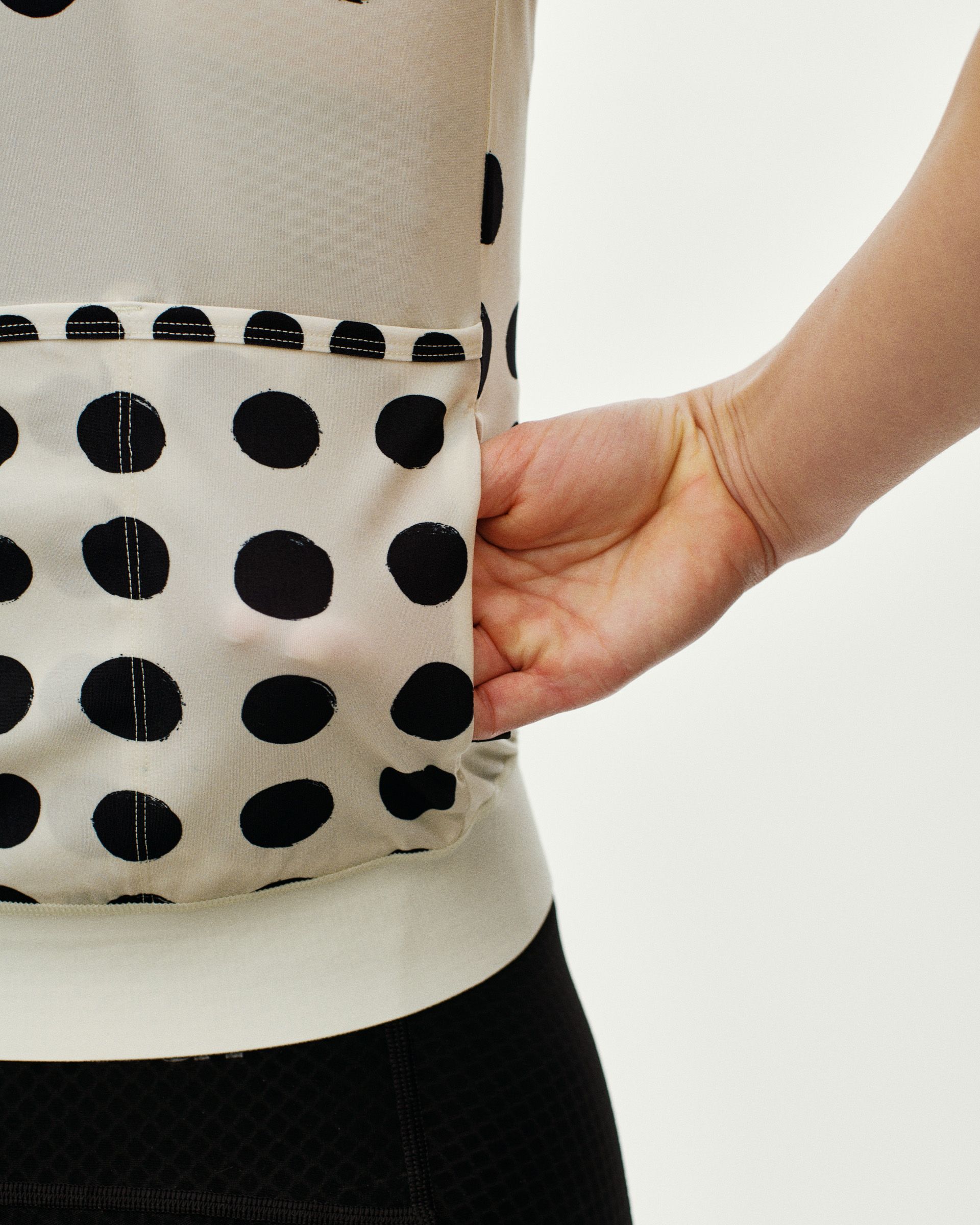 Off White Essential women's cycling jersey, rear detail on model showing polka dot back pocket
