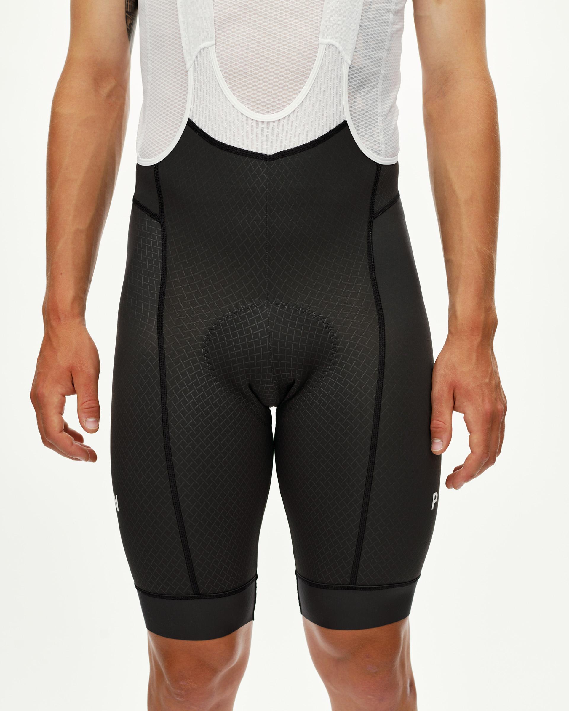 Dark Navy Mechanism cycling bibs on model, front view with tonal grid-pattern panel
