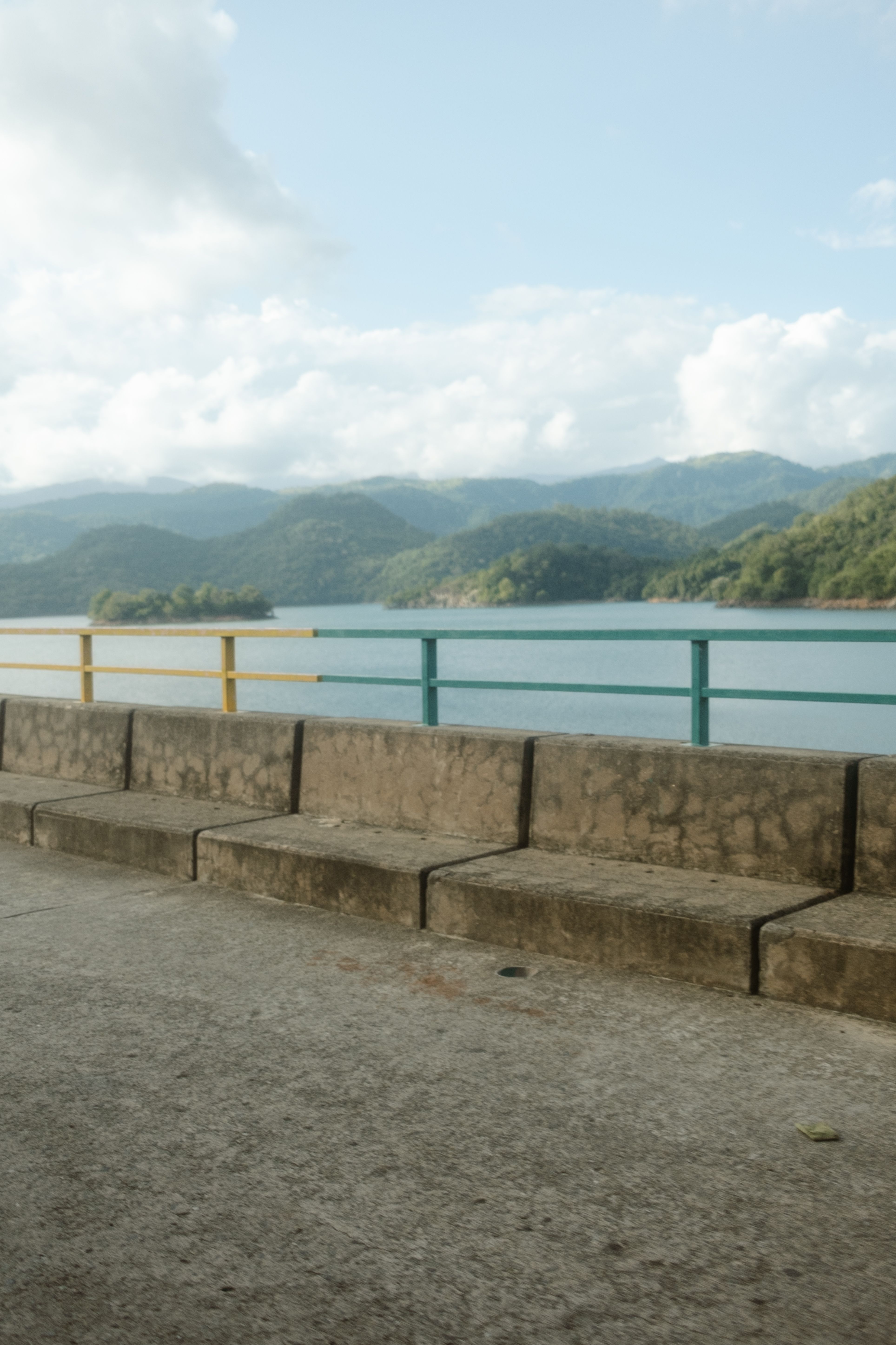 Stone steps overlooking lake with forested mountains under cloudy sky