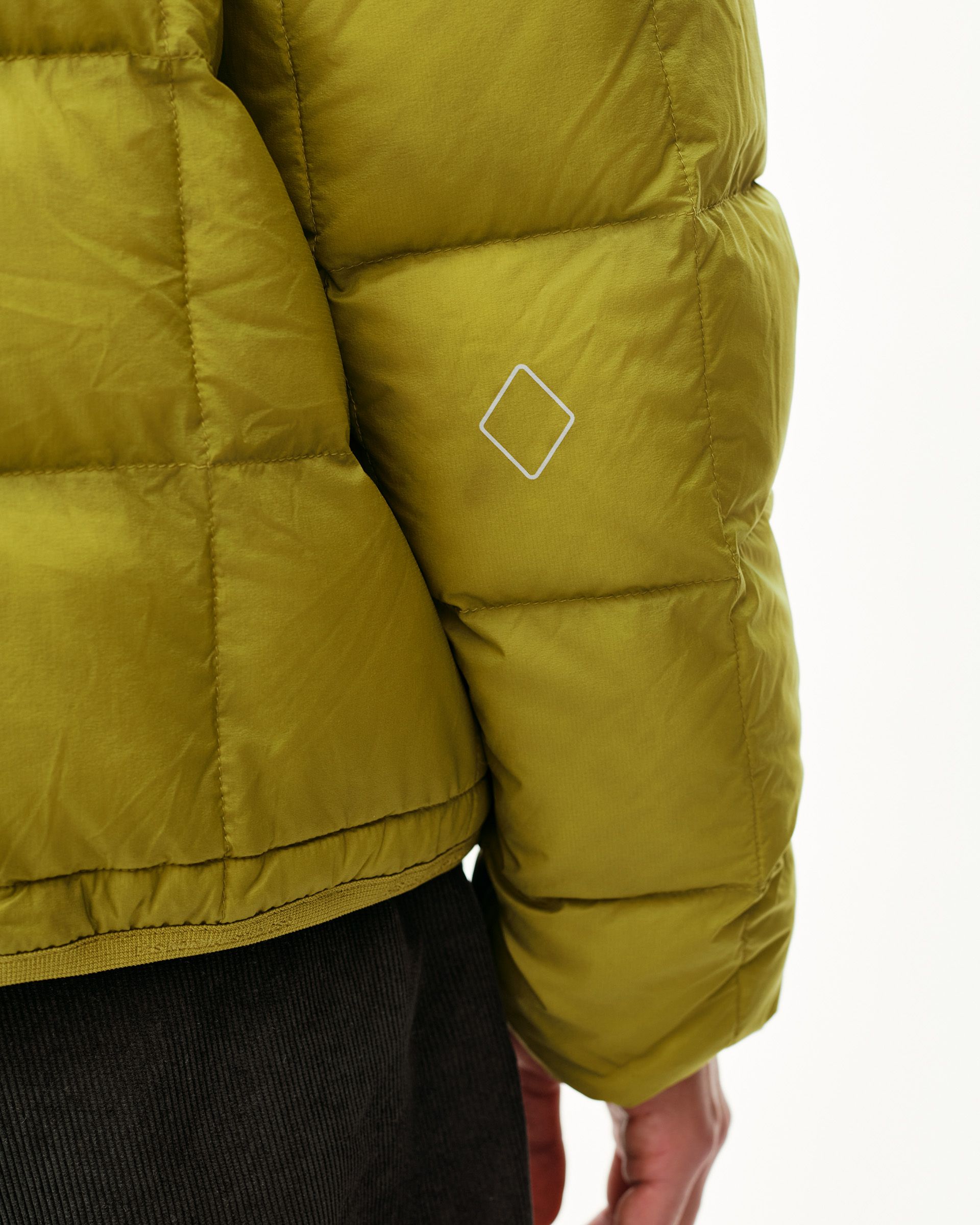 Dark Lime green Off-Race Down Liner jacket, side detail on model with white diamond logo on sleeve