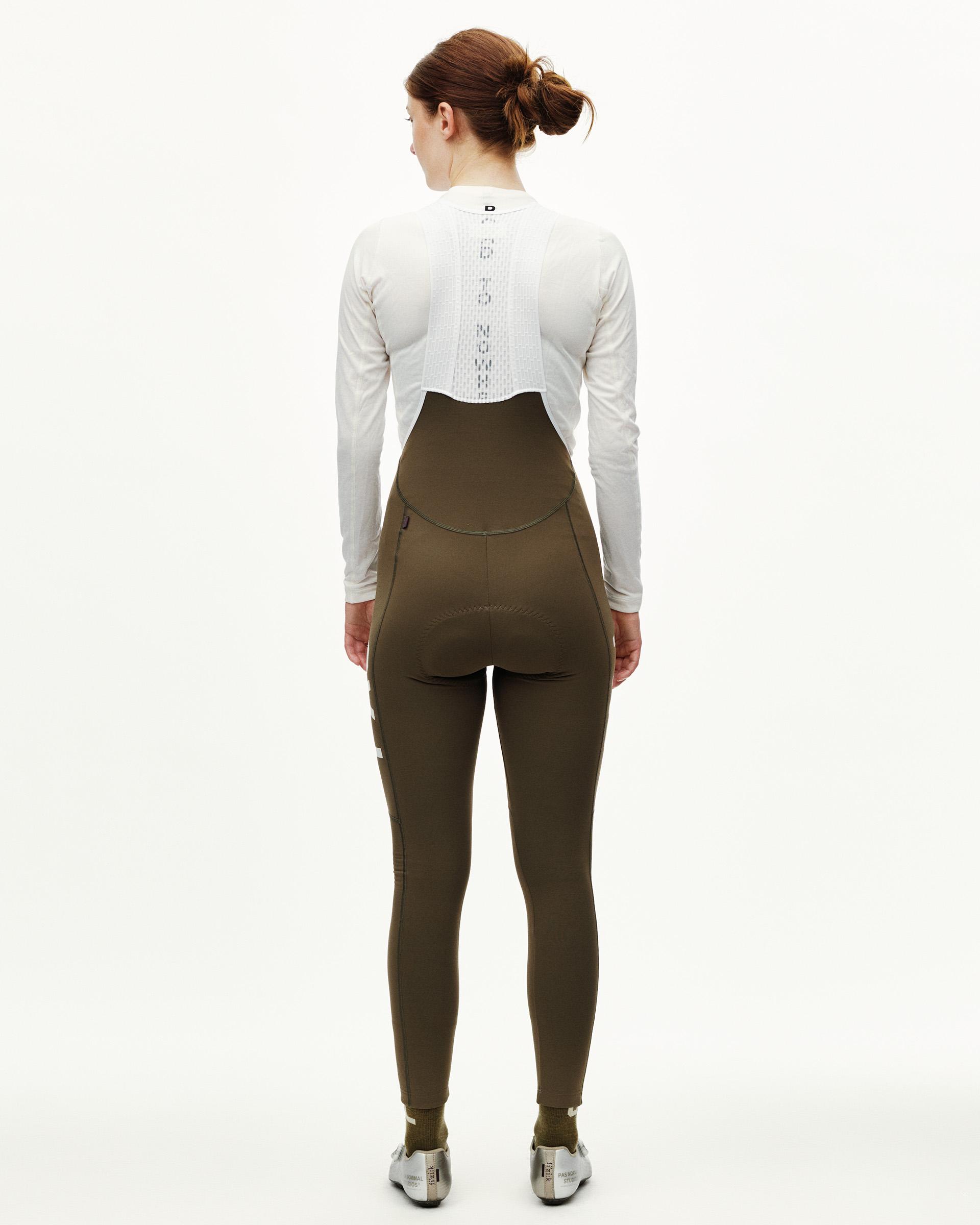 Dark Earth khaki PAS Mechanism women's thermal cycling long bibs on model, rear view