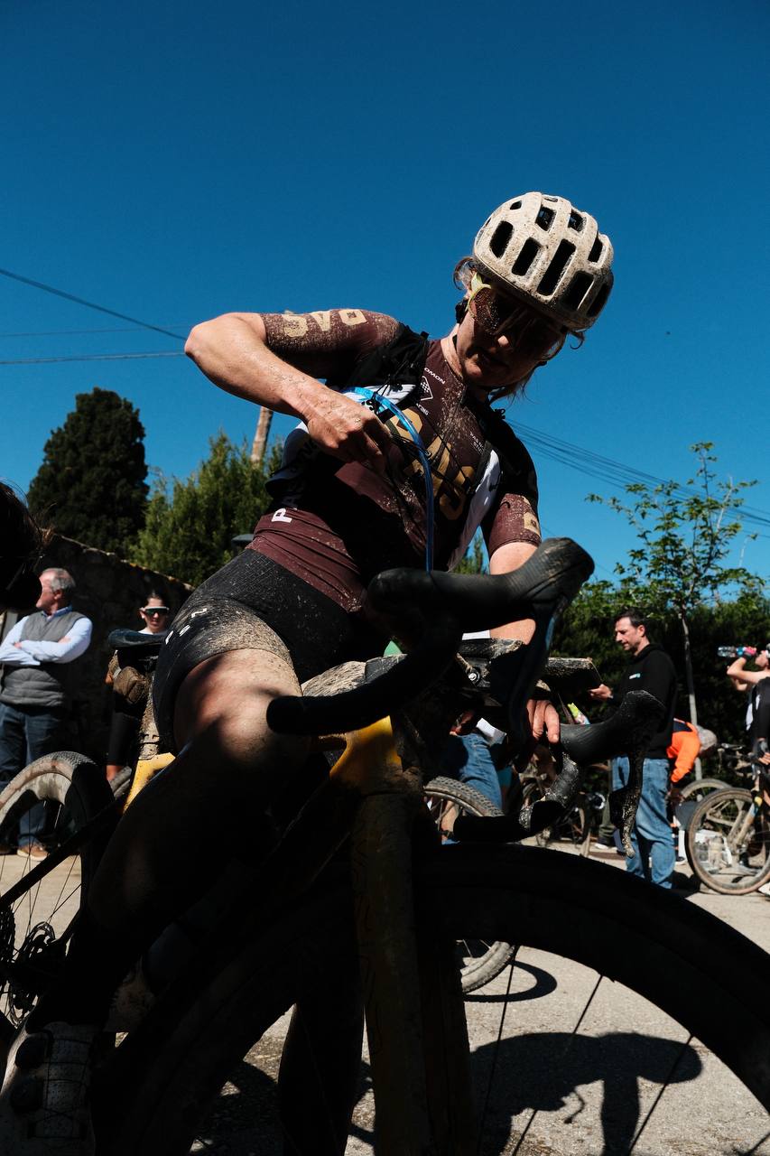 Model wearing brown Mechanism jersey and bib shorts at cyclocross race with white helmet
