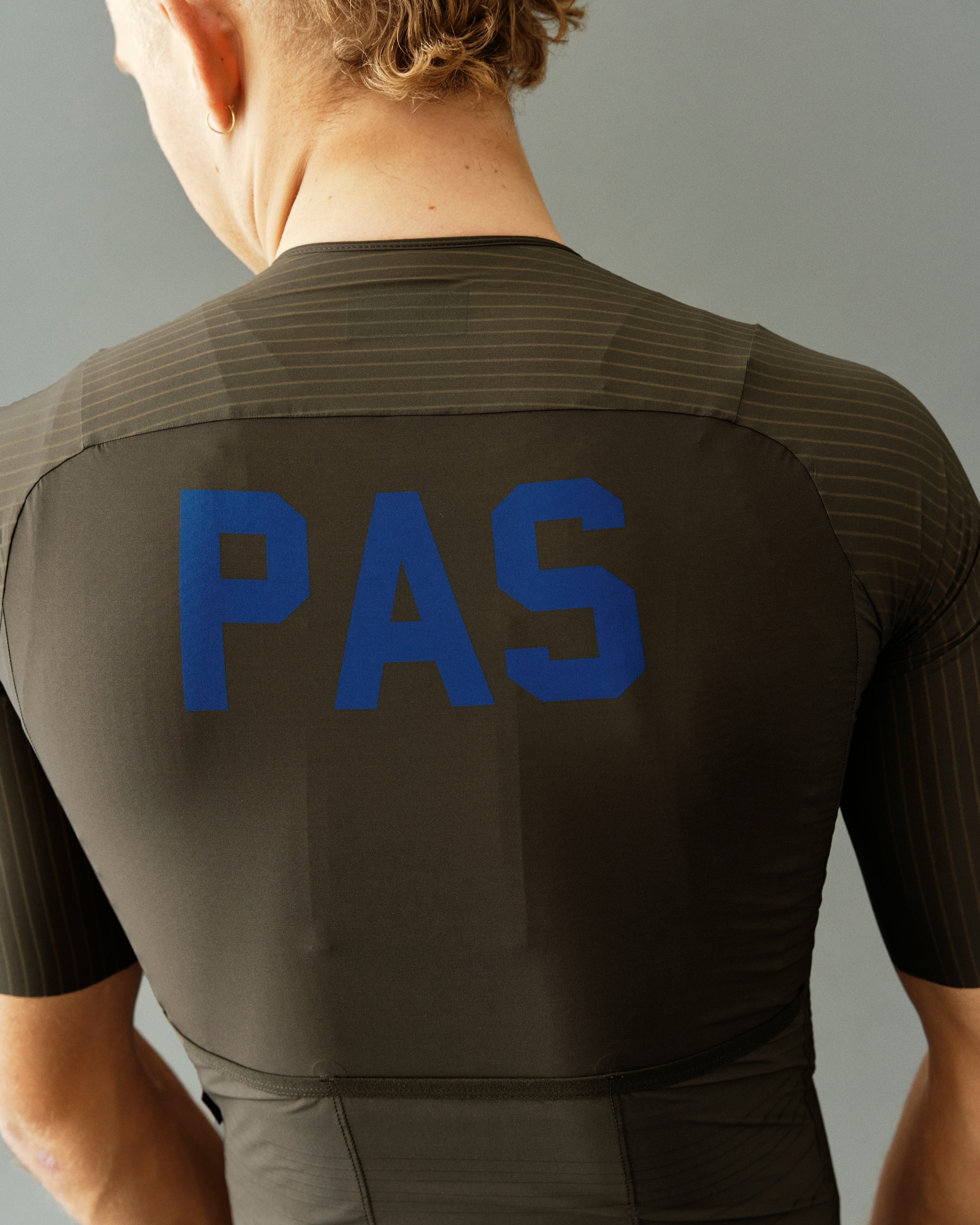 Dark Olive PAS Mechanism Pro cycling jersey, rear view on model with blue back print