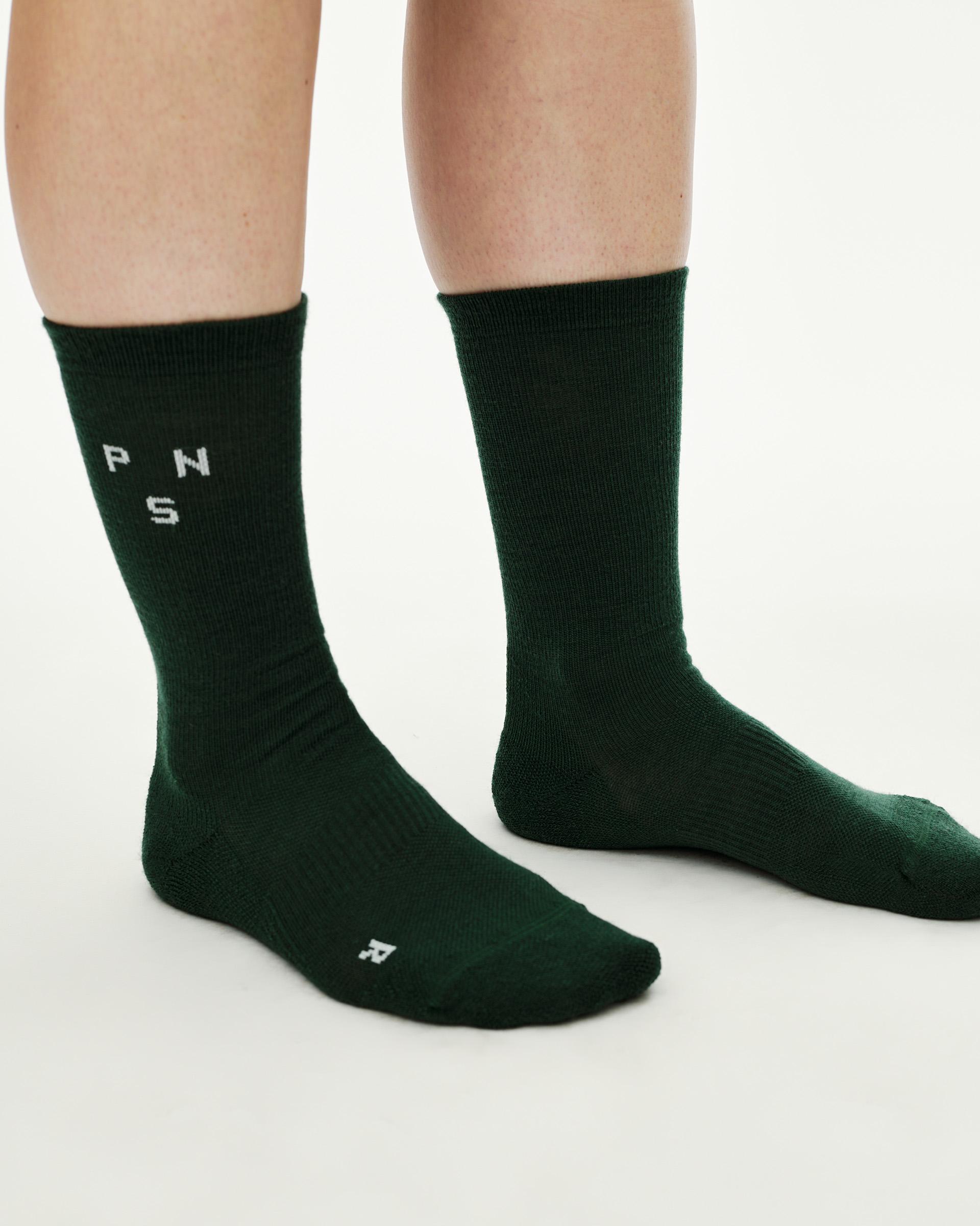 Petroleum green Essential Thermal Wool cycling socks on model, side view with white knit logo on cuff