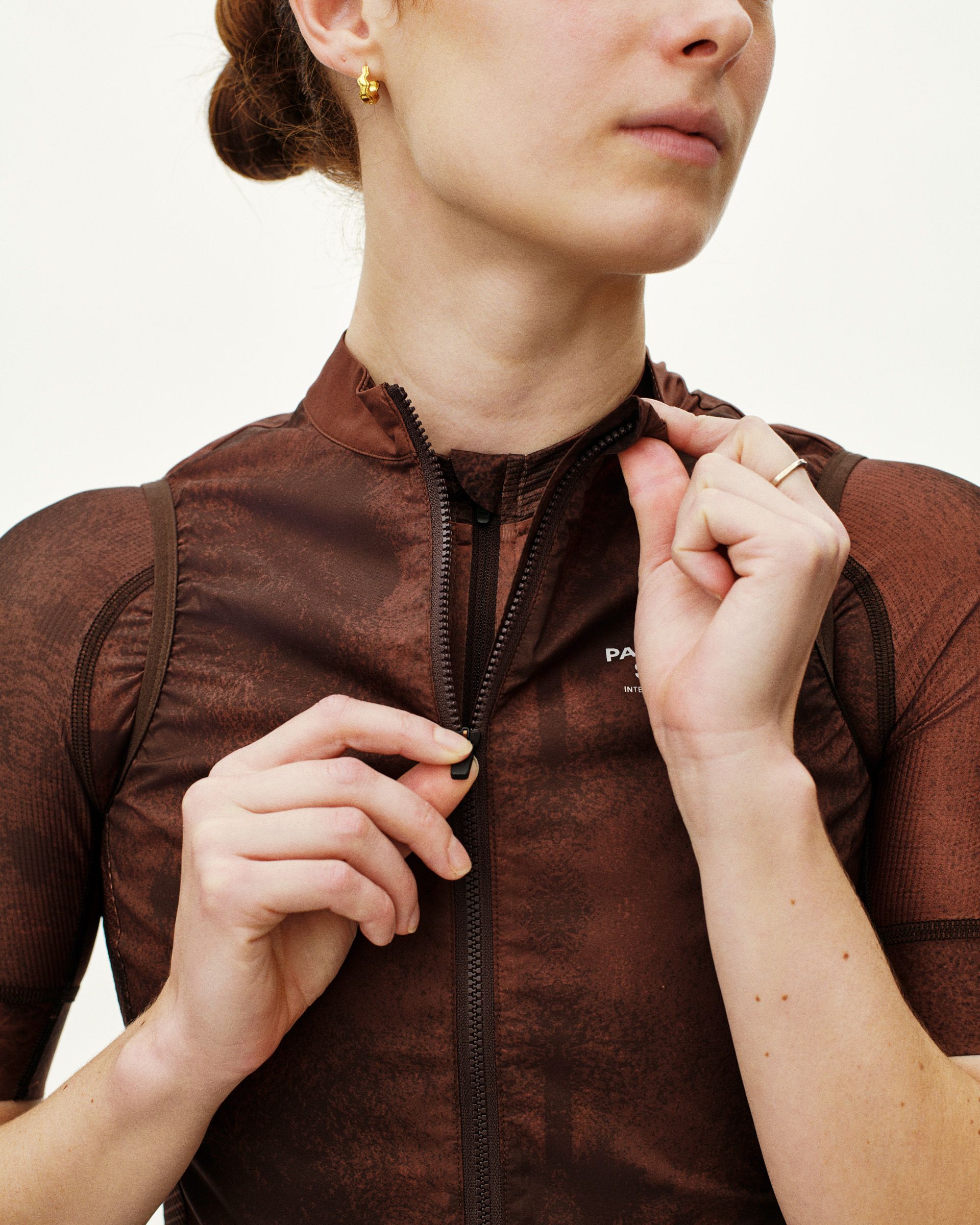 Brown Mechanism Stow Away gilet on model with full zip and ribbed panels