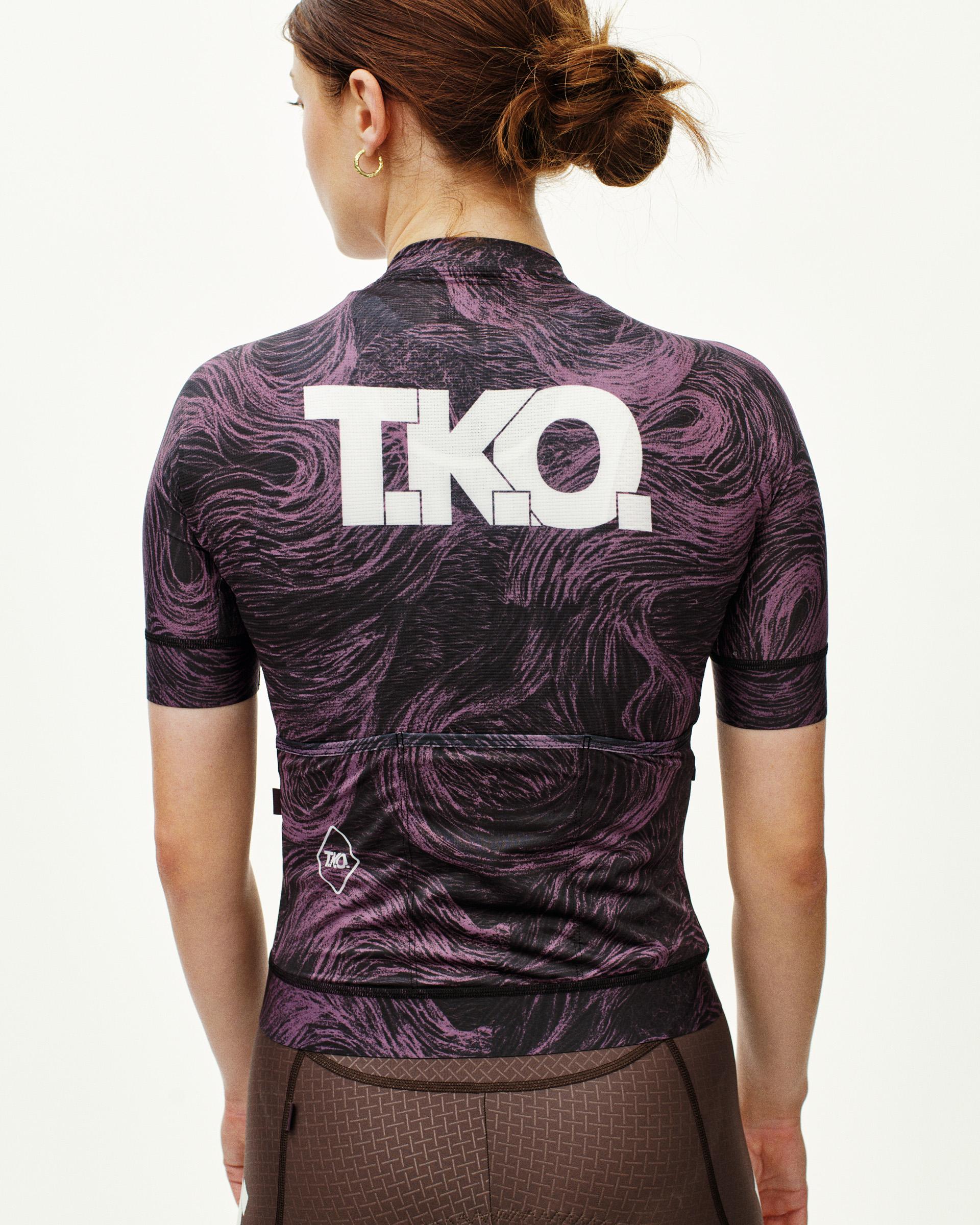 Mauve T.K.O. Mechanism cycling jersey on model, rear view with swirl print and white T.K.O. back logo