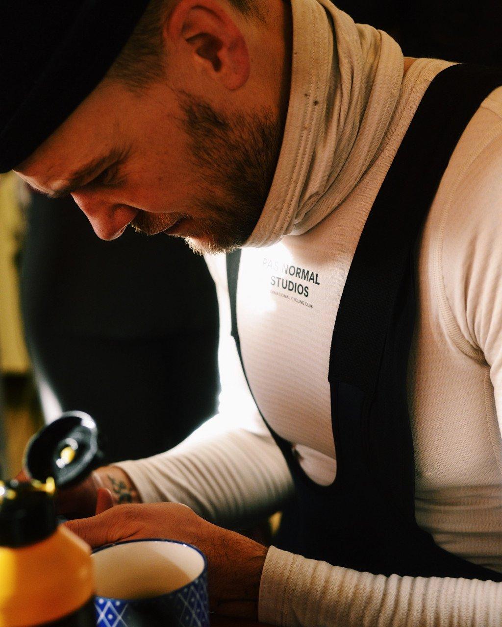 Model wearing white jersey with logo branding seated indoors