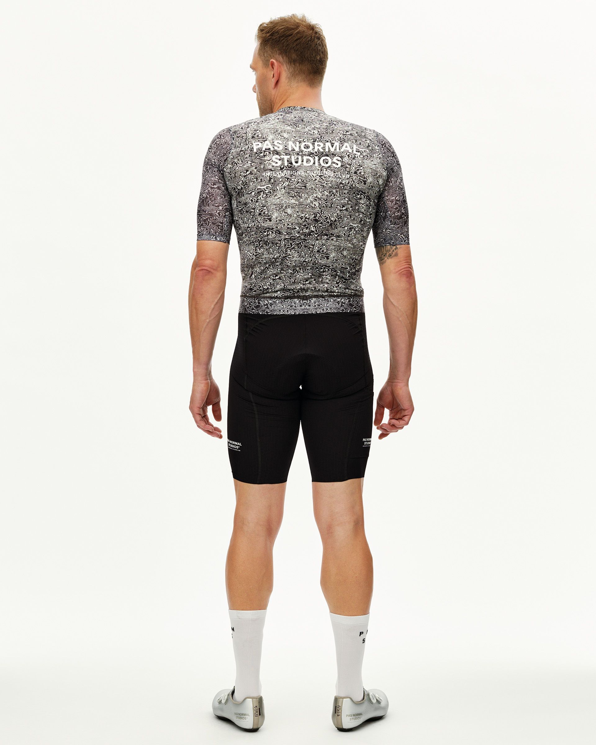 Off White Essential Light men's cycling jersey on model, rear view with all-over swirl print