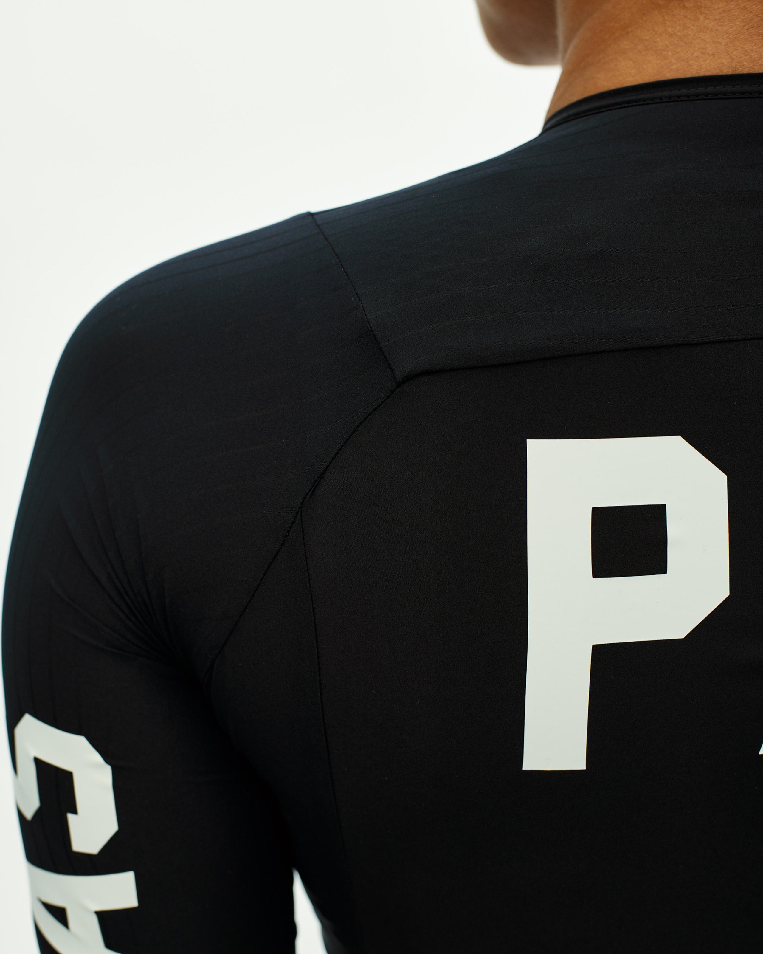 Black PAS Mechanism Pro cycling jersey, rear three-quarter view with white letter P print