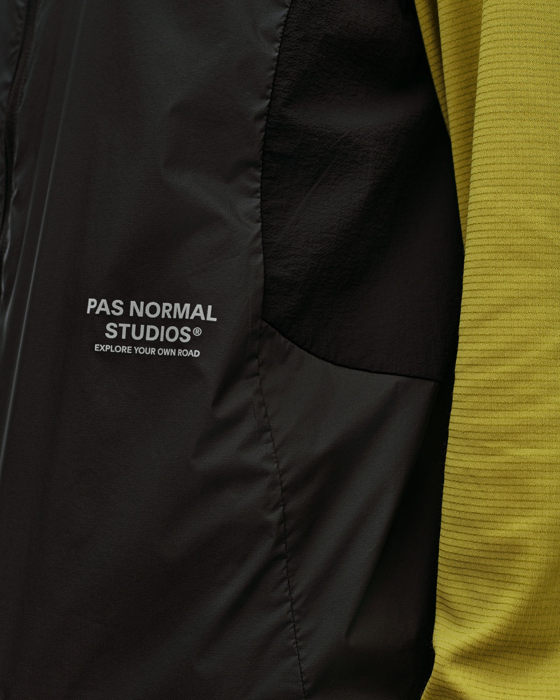Black Balance Windproof Vest, detail view of chest logo print and curved side panel seam