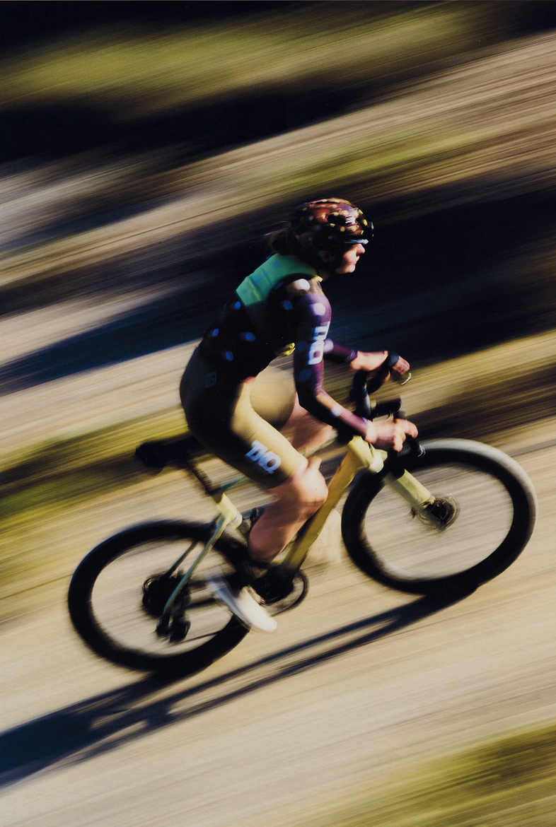 Cyclist in T.K.O. collection jersey riding time trial bike with motion blur effect