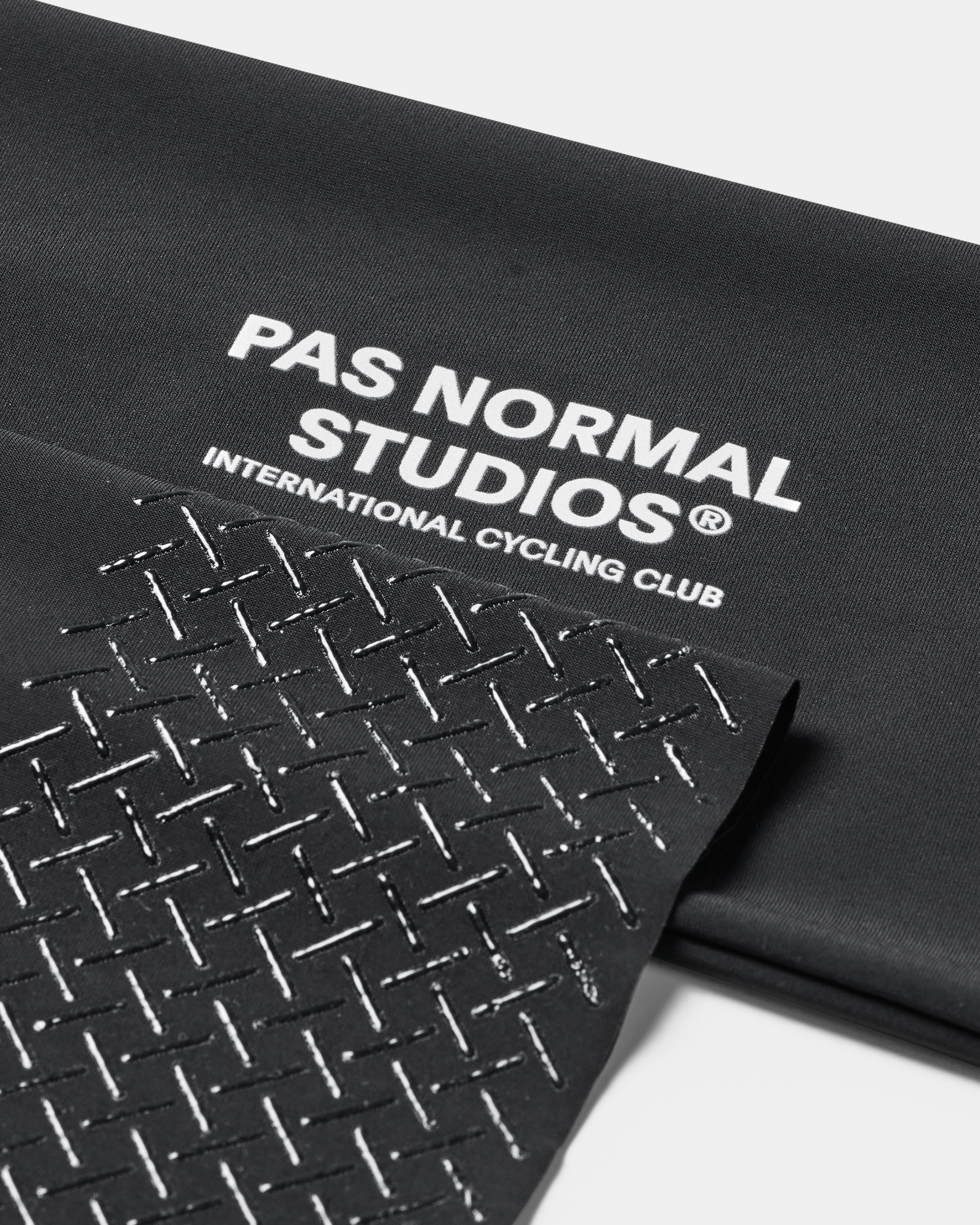 Black Logo Arm UV Protector, detail view showing white text and geometric pattern