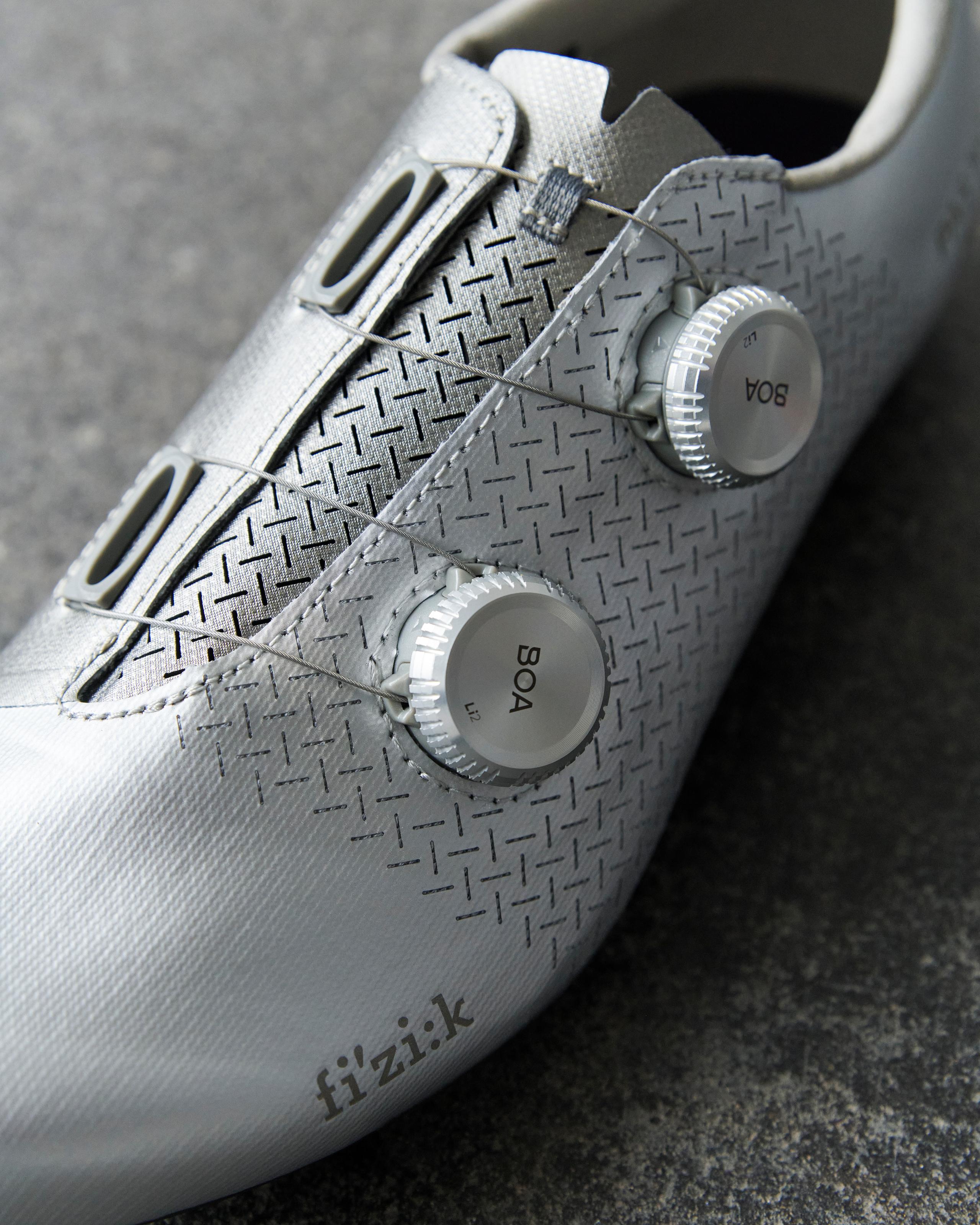 White Fizik Mechanism road cycling shoes, side detail view with dual BOA dials and textured upper