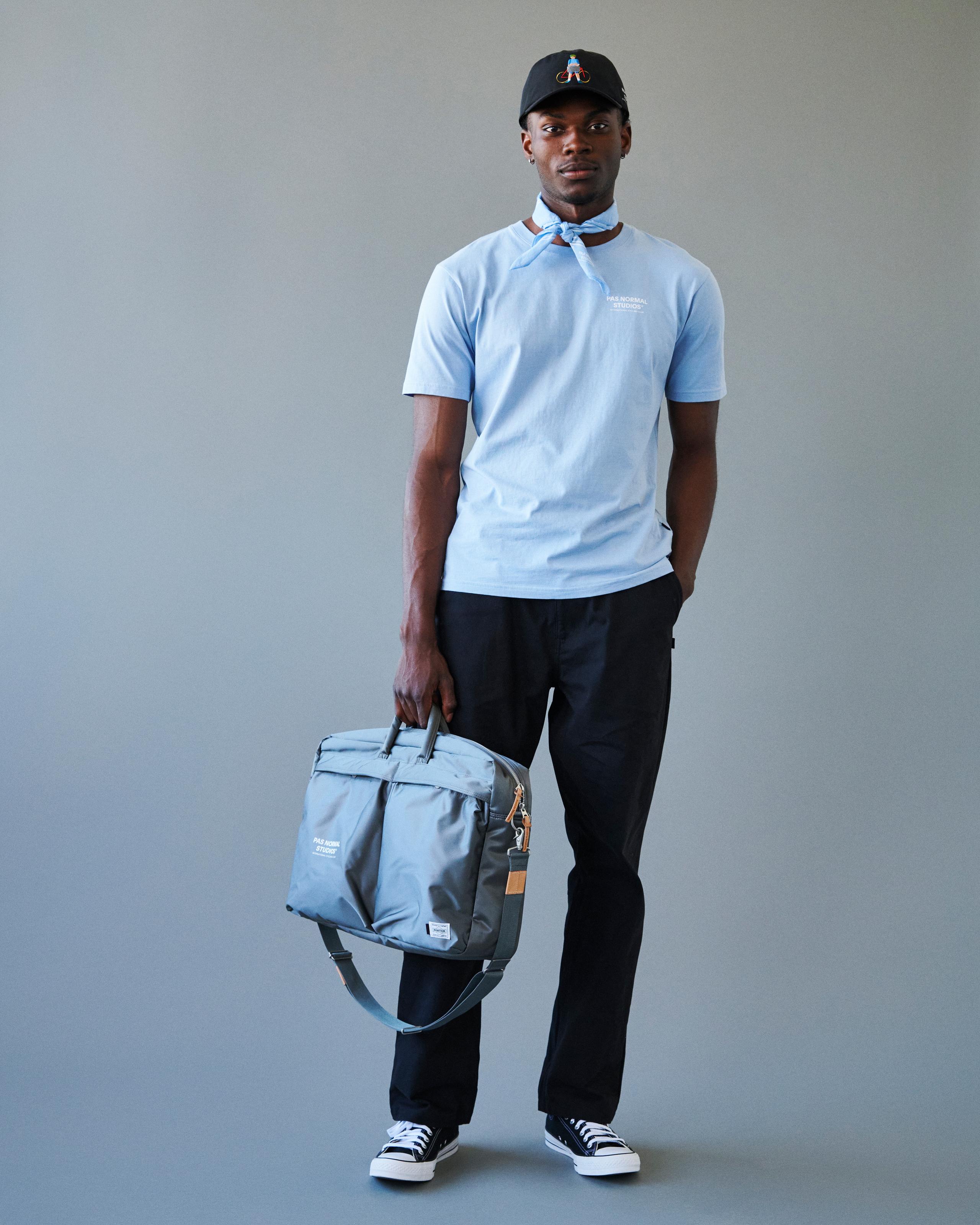 Grey Porter-Yoshida 2-Way Briefcase on model with shoulder strap and leather accent