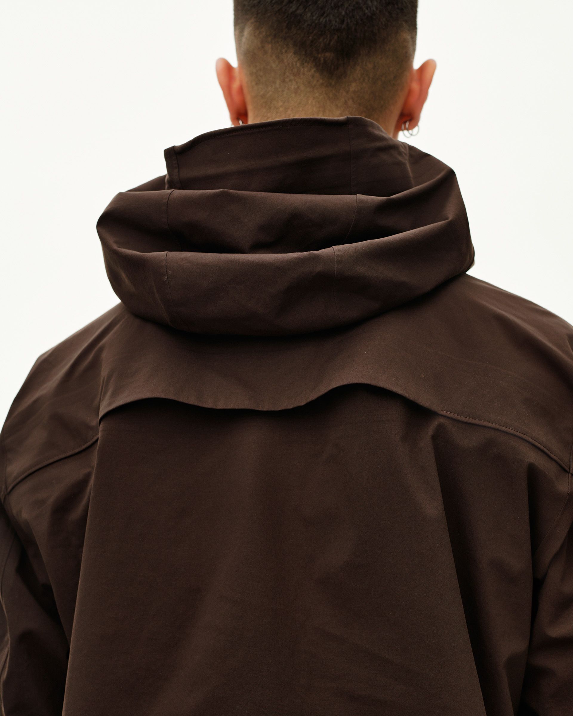 Dark Coffee brown Off-Race 3L Shell jacket on model, rear view with structured storm hood