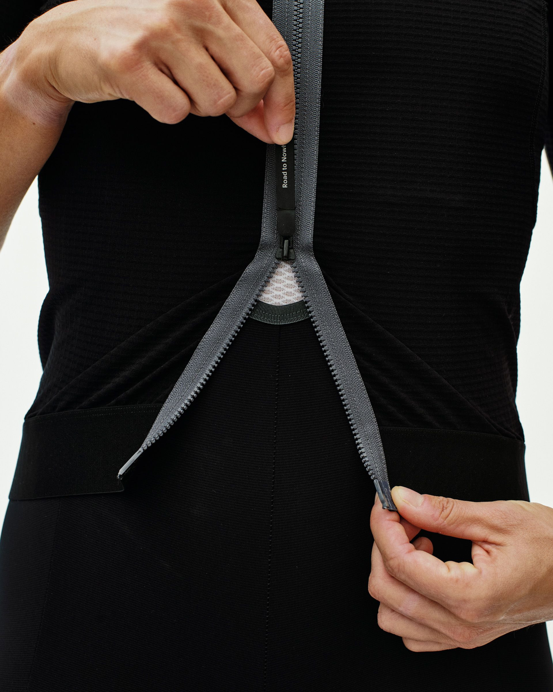 Black Escapism cycling jersey on model showing opened rear zip with white mesh inner panel