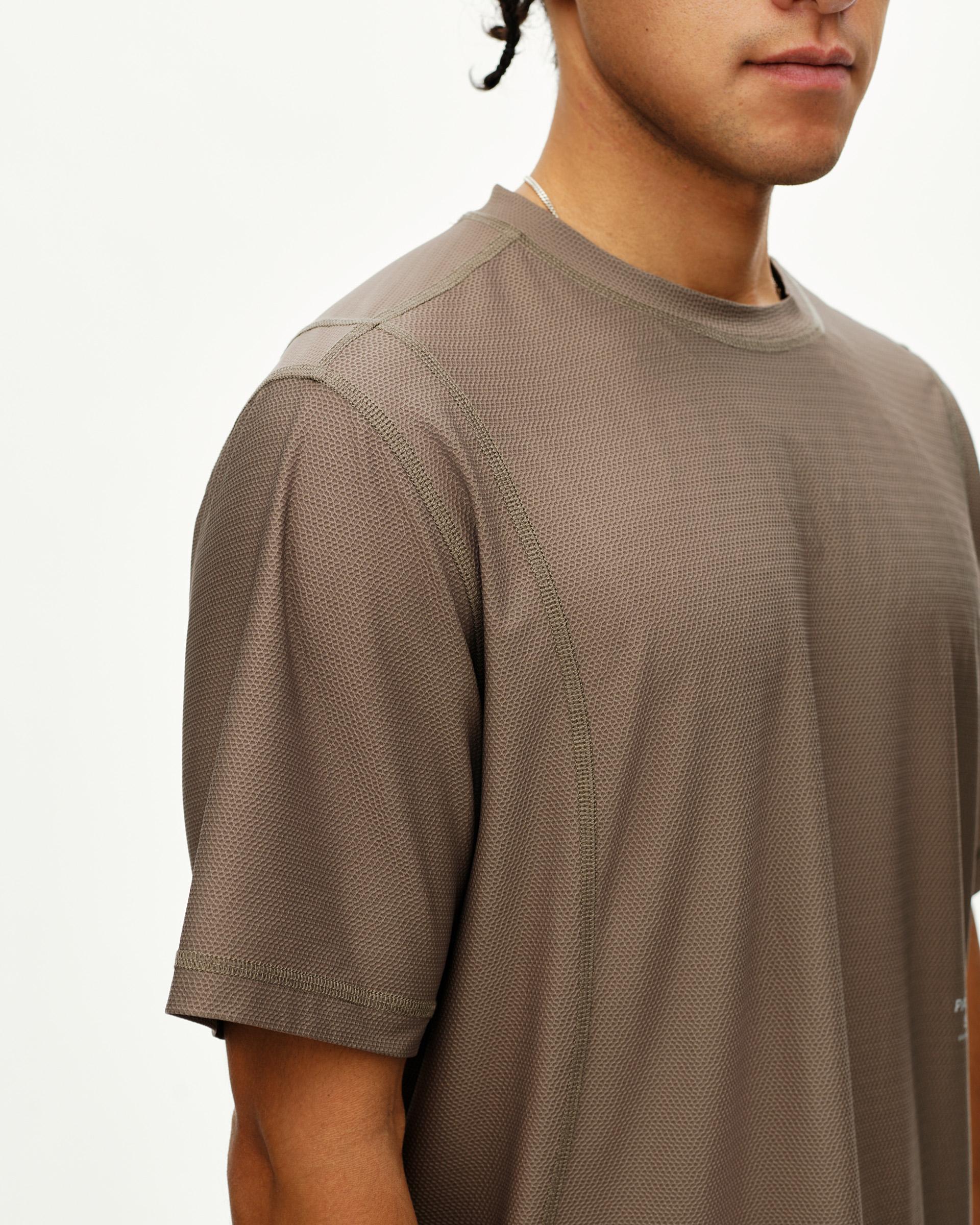 Stone Brown Balance T-shirt on model, side detail view with textured fabric and contrast stitching