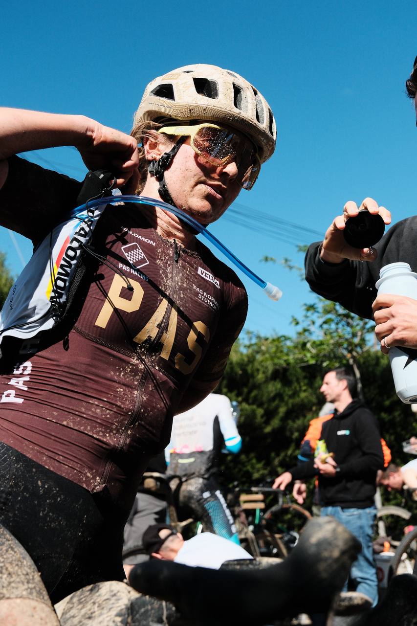Model wearing brown Mechanism Jersey with logo lettering during cycling race