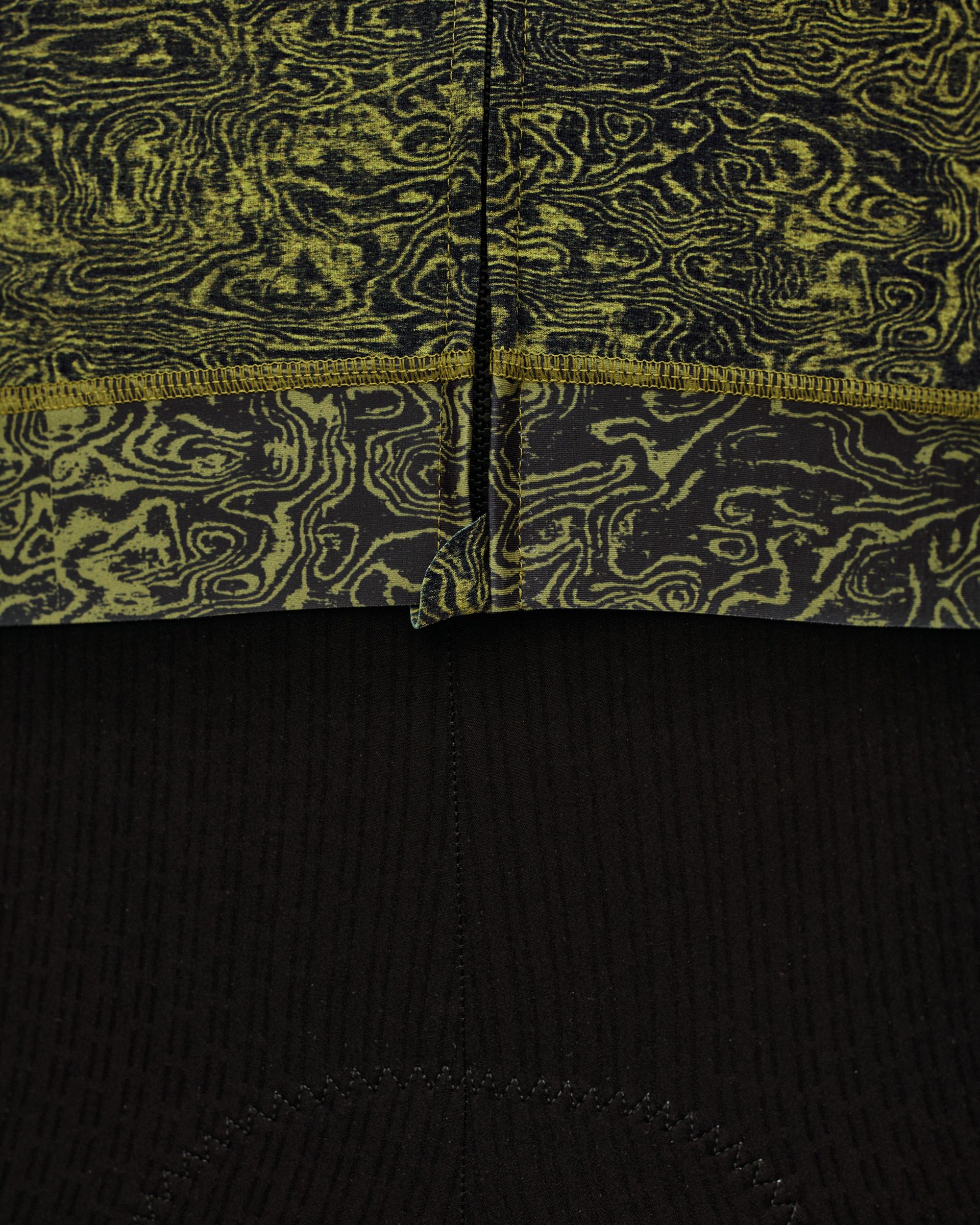 Dark Lime Essential cycling jersey, rear hem detail with swirl AOP print and serged seam above black bib panel