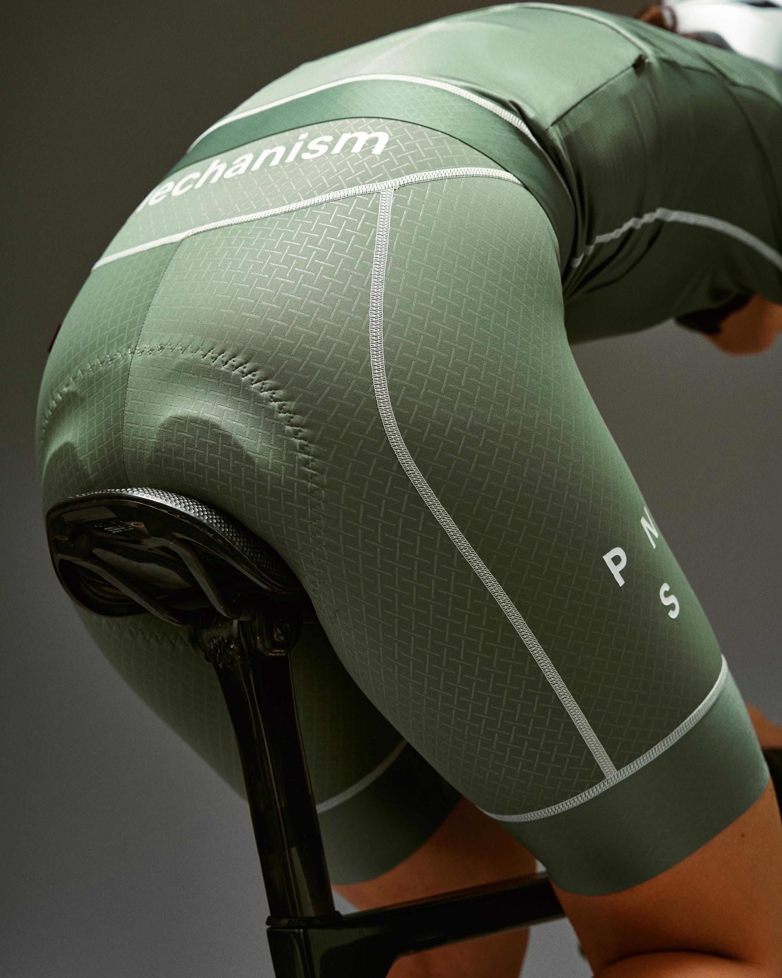 Khaki Green Mechanism bibs on model with geometric textured panels and white contrast stitching