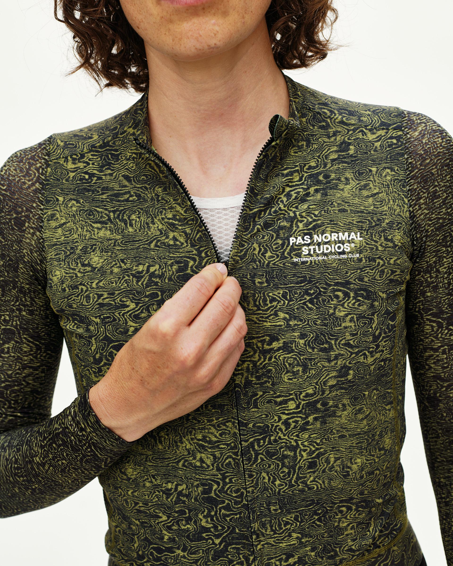 Dark Lime Essential long sleeve cycling jersey on model, front detail with swirl AOP and chest logo print