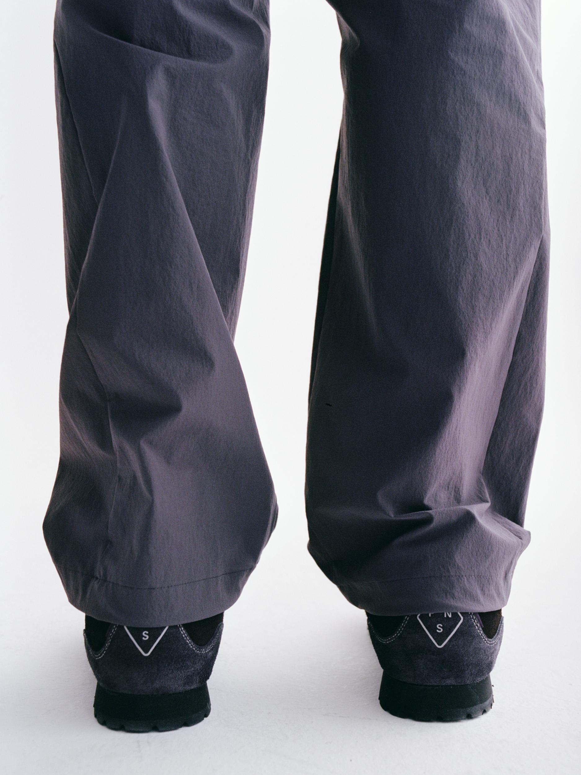 Grey Off-Race Tech pants on model, rear view with elastic cuffs